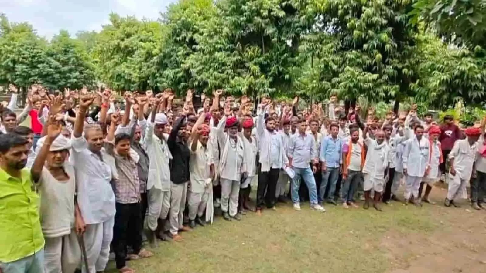 तस्वीर में गोकुलपुरा के ग्रामीण पेड़ों के सामने खड़े होकर हाथ उठाकर नारेबाजी कर रहे हैं। तस्वीर में गोकुलपुरा के ग्रामीण पेड़ों के सामने खड़े होकर हाथ उठाकर नारेबाजी कर रहे हैं।