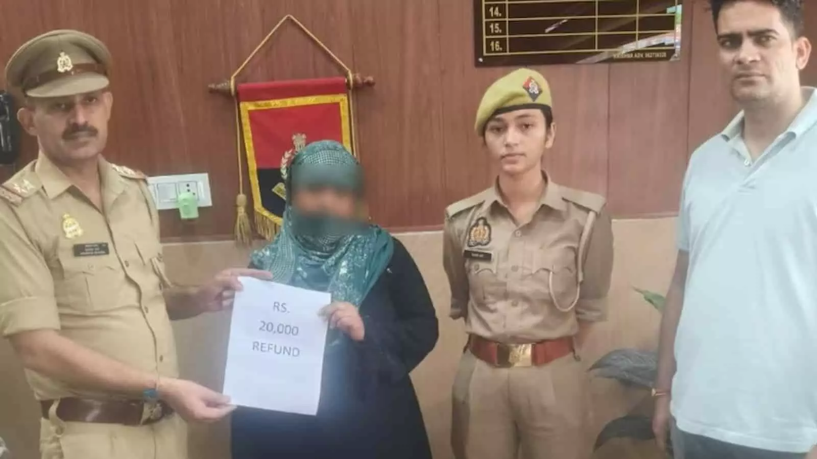तस्वीर में पुलिस अधिकारियों के साथ महिला RS 20,000 REFUND का कागज पकड़े हुए नजर आ रही है। तस्वीर में पुलिस अधिकारियों के साथ महिला RS 20,000 REFUND का कागज पकड़े हुए नजर आ रही है।