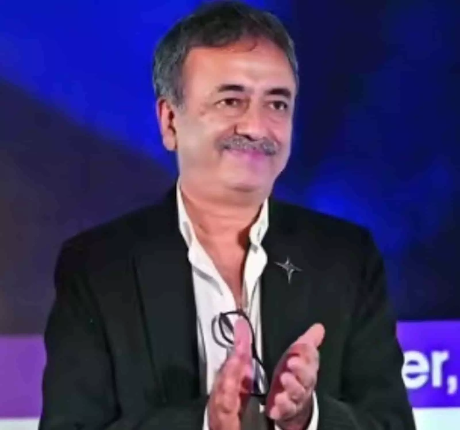 तस्वीर में फिल्ममेकर राजकुमार हिरानी काले कोट और सफेद शर्ट में नजर आ रहे हैं। तस्वीर में फिल्ममेकर राजकुमार हिरानी काले कोट और सफेद शर्ट में नजर आ रहे हैं।