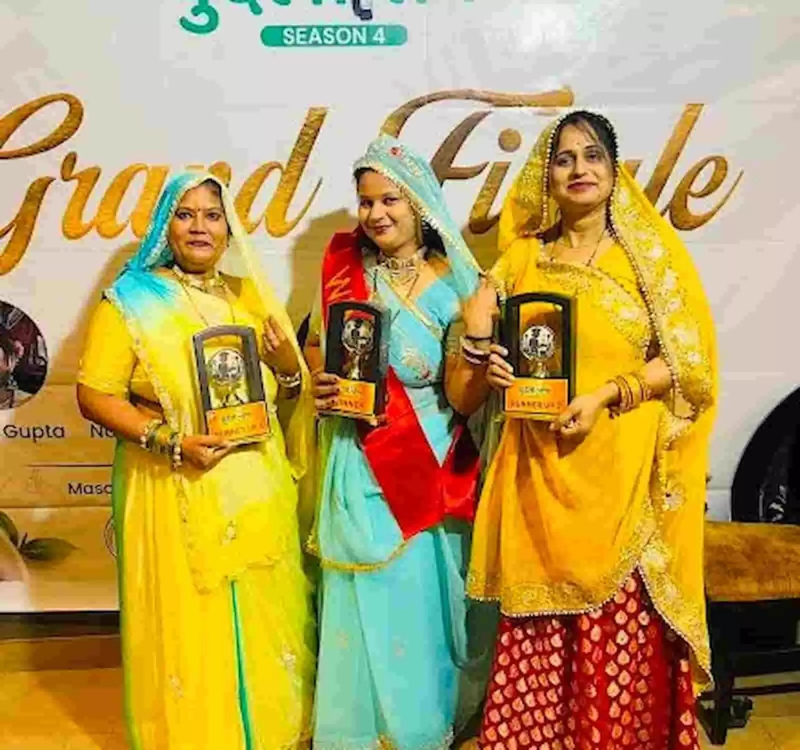 झांसी में आयोजित कार्यक्रम में पारंपरिक पोशाक पहने तीन महिलाएं हाथों में ट्रॉफी लिए मुस्कुराती दिख रही हैं। झांसी में आयोजित कार्यक्रम में पारंपरिक पोशाक पहने तीन महिलाएं हाथों में ट्रॉफी लिए मुस्कुराती दिख रही हैं।