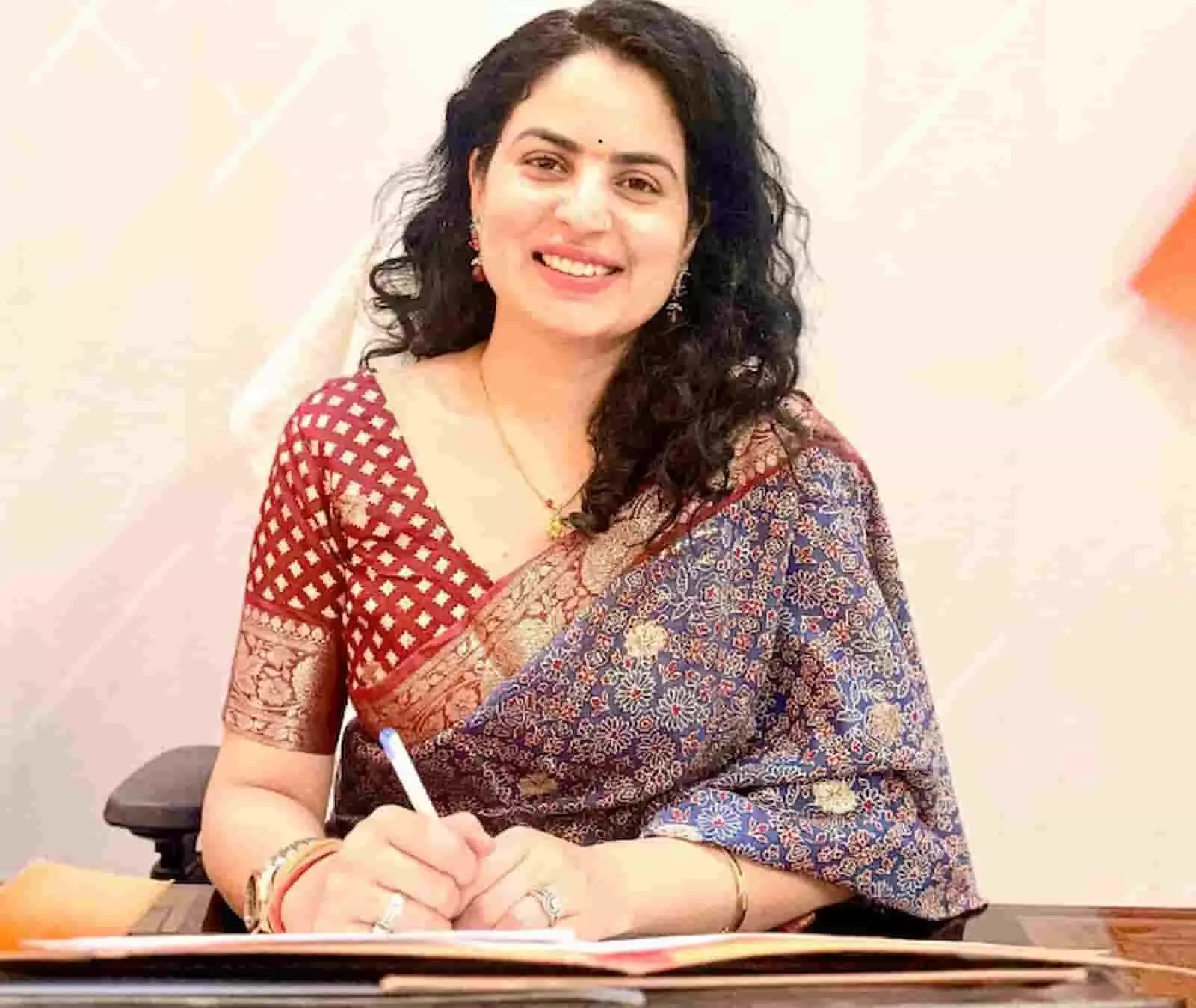 कार्यालय में मेज पर बैठकर कागजात पर लिखती हुई महिला अधिकारी। कार्यालय में मेज पर बैठकर कागजात पर लिखती हुई महिला अधिकारी।