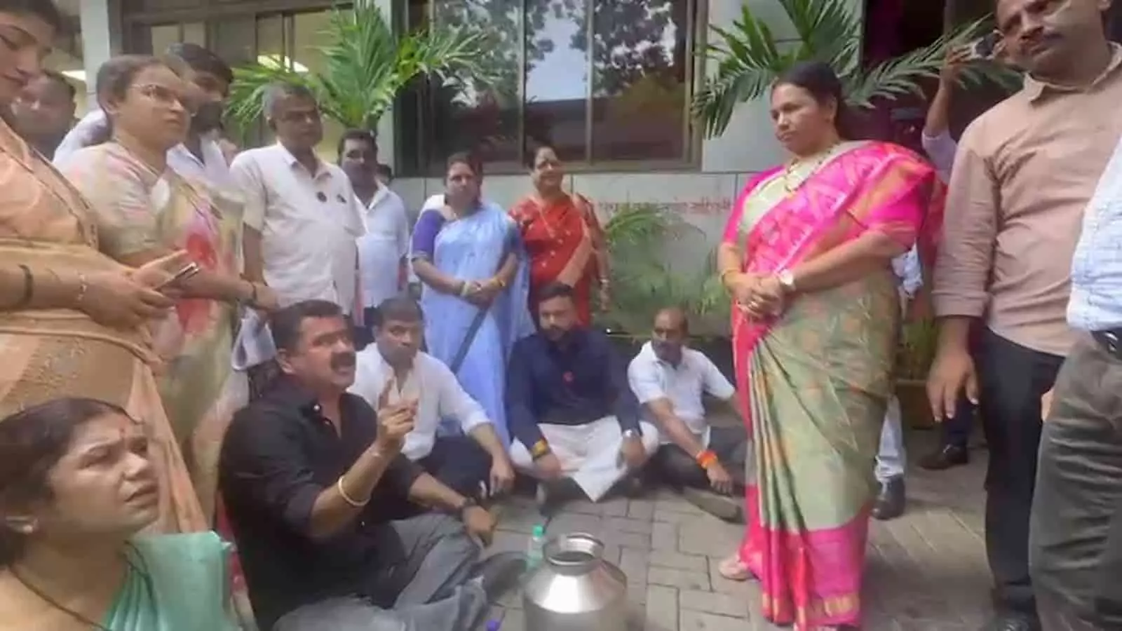 तस्वीर में मुंबई के बीएमसी कार्यालय परिसर में खाली बर्तन रखकर जमीन पर बैठे और खड़े लोग दिख रहे हैं। तस्वीर में मुंबई के बीएमसी कार्यालय परिसर में खाली बर्तन रखकर जमीन पर बैठे और खड़े लोग दिख रहे हैं।