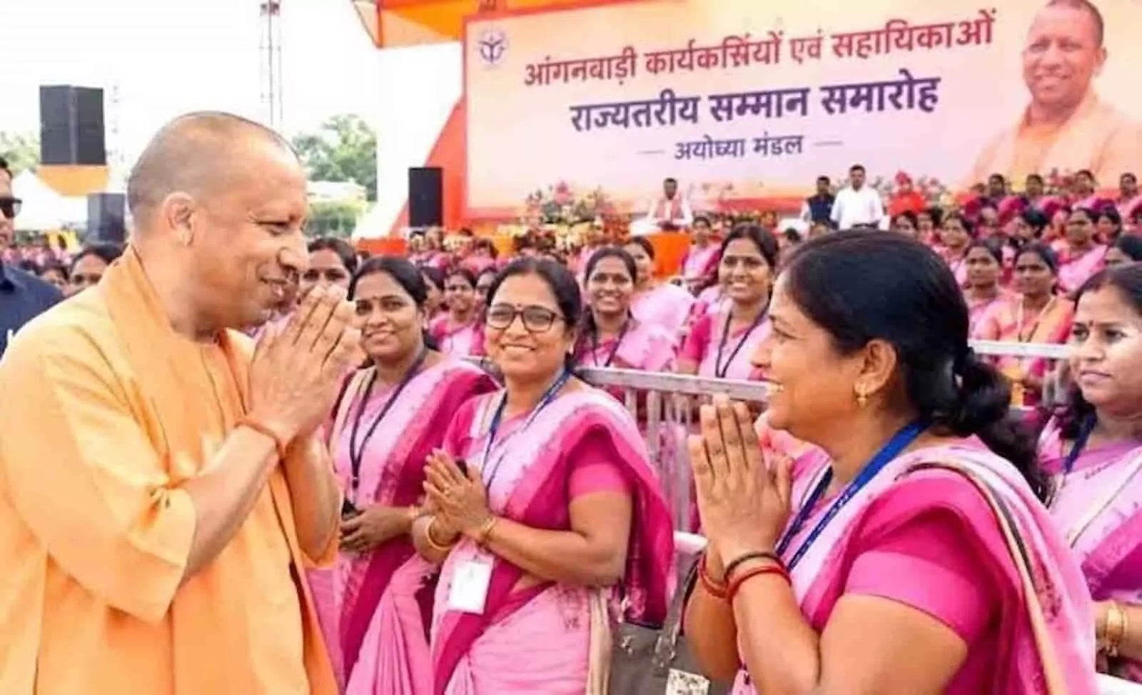 तस्वीर में बाएं योगी आदित्यनाथ और दाएं खड़ी गुलाबी साड़ी पहनी आंगनबाड़ी कार्यकर्ता हाथ जोड़कर नमस्ते कर रही हैं। तस्वीर में बाएं योगी आदित्यनाथ और दाएं खड़ी गुलाबी साड़ी पहनी आंगनबाड़ी कार्यकर्ता हाथ जोड़कर नमस्ते कर रही हैं।