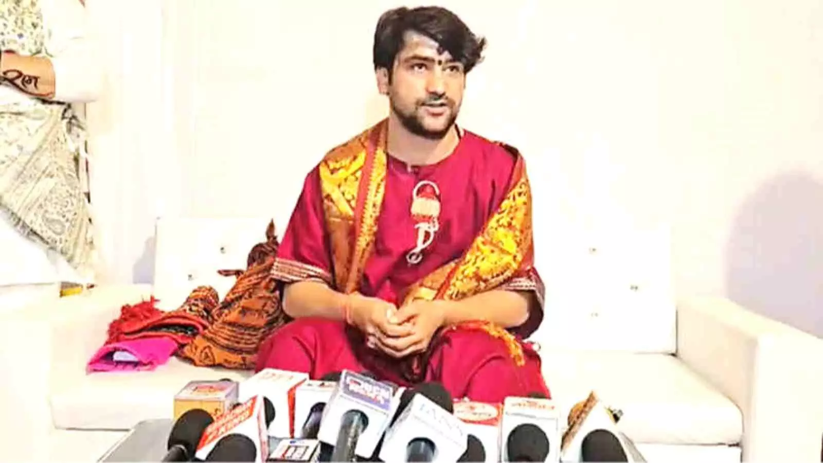 धीरेंद्र शास्त्री माइक के सामने विवादित बयान और पुलिस शिकायत के संदर्भ में बैठे हुए नजर आ रहे हैं। धीरेंद्र शास्त्री माइक के सामने विवादित बयान और पुलिस शिकायत के संदर्भ में बैठे हुए नजर आ रहे हैं।