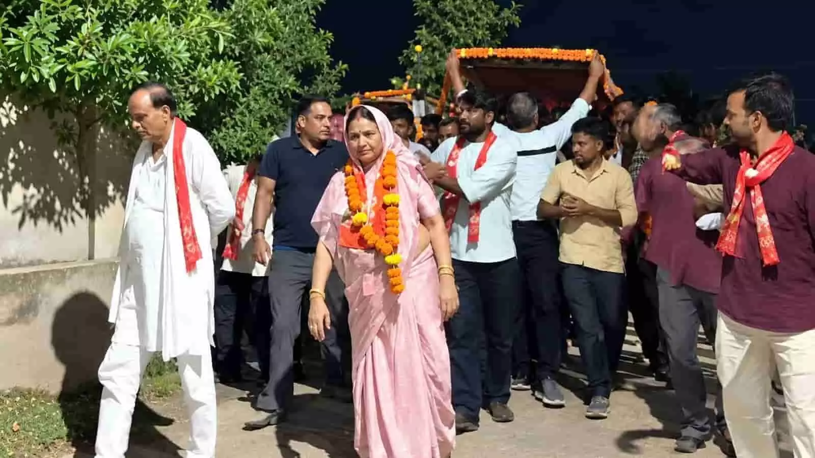 तस्वीर में गुलाबी साड़ी और फूलों की माला पहने राजेश्वरी गुर्जर समर्थकों के साथ पैदल चल रही हैं। तस्वीर में गुलाबी साड़ी और फूलों की माला पहने राजेश्वरी गुर्जर समर्थकों के साथ पैदल चल रही हैं।
