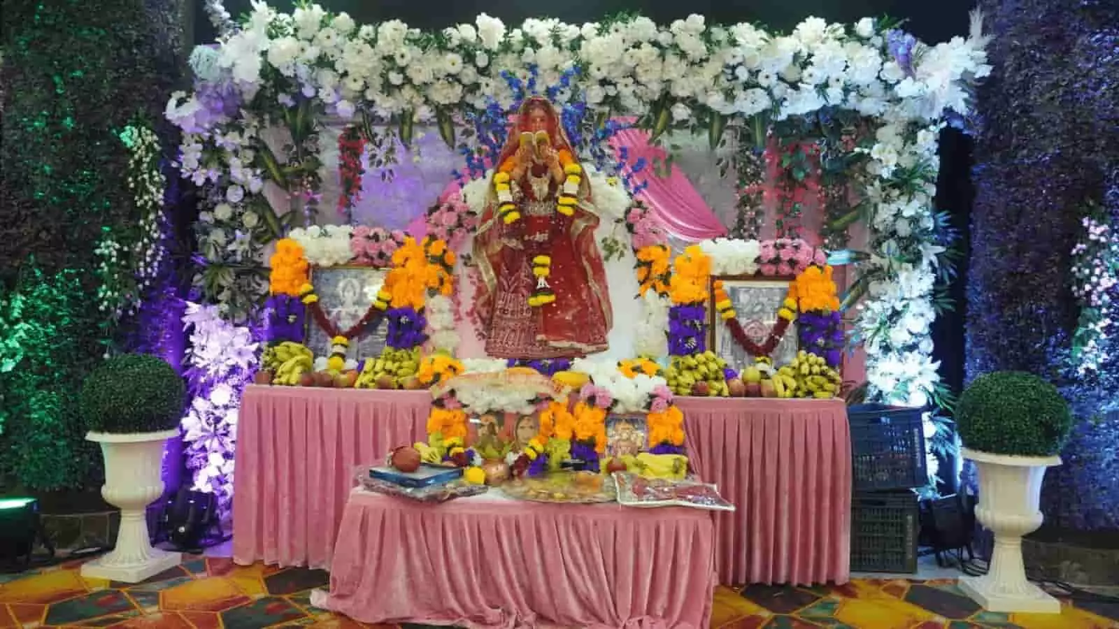 तस्वीर में फूलों और झालरों से सजे मंच पर श्री सावित्री माता की सुंदर मूर्ति और तस्वीरें रखी हुई हैं। तस्वीर में फूलों और झालरों से सजे मंच पर श्री सावित्री माता की सुंदर मूर्ति और तस्वीरें रखी हुई हैं।