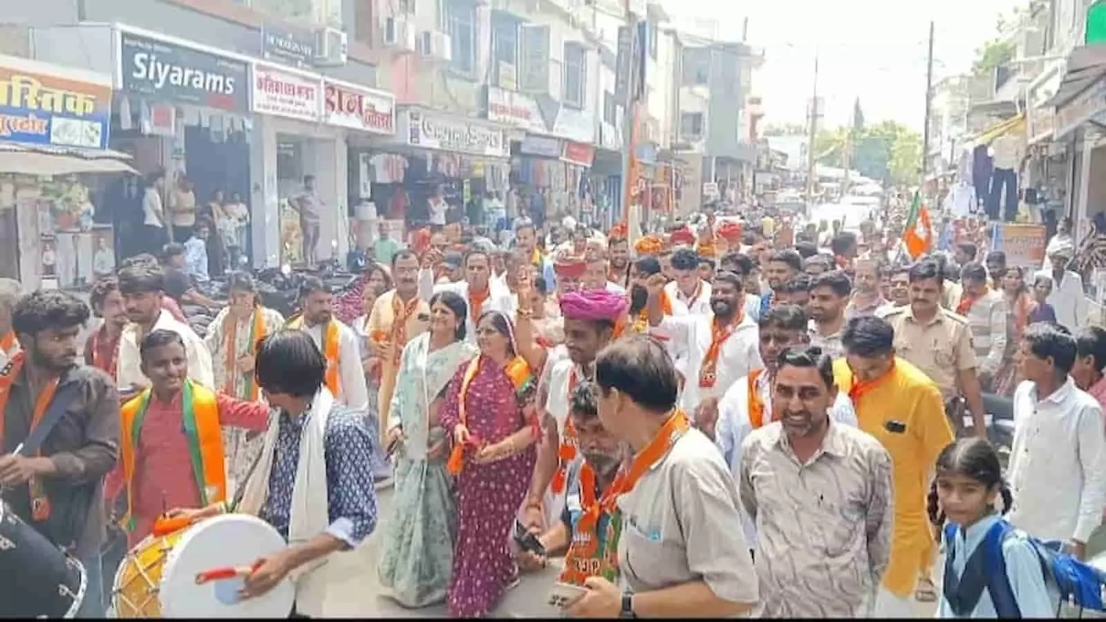 तस्वीर में गंगापुर के बाजार में जुलूस और रोड शो के दौरान बड़ी संख्या में लोग और कार्यकर्ता चल रहे हैं। तस्वीर में गंगापुर के बाजार में जुलूस और रोड शो के दौरान बड़ी संख्या में लोग और कार्यकर्ता चल रहे हैं।