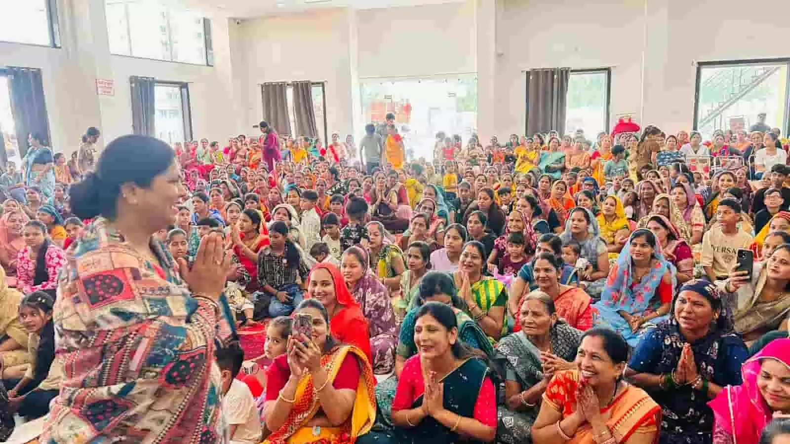 तस्वीर में बाईं ओर खड़ी राखी गौतम हाथ जोड़कर हाल में बैठी महिलाओं का नमस्कार कर रही हैं। तस्वीर में बाईं ओर खड़ी राखी गौतम हाथ जोड़कर हाल में बैठी महिलाओं का नमस्कार कर रही हैं।