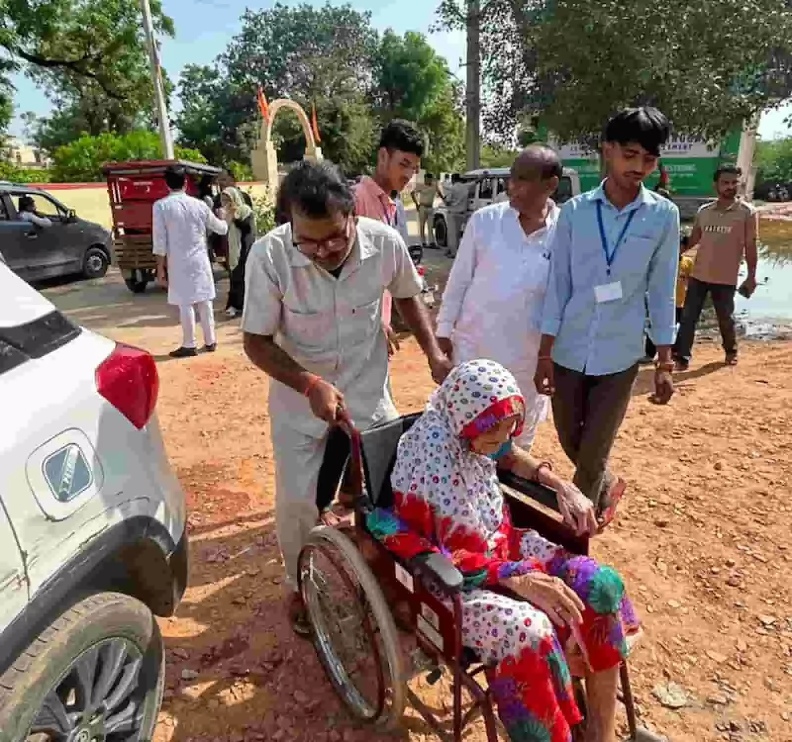 तस्वीर में दिख रही बुजुर्ग महिला को व्हीलचेयर के सहारे लोग मतदान केंद्र की ओर ले जा रहे हैं। तस्वीर में दिख रही बुजुर्ग महिला को व्हीलचेयर के सहारे लोग मतदान केंद्र की ओर ले जा रहे हैं।