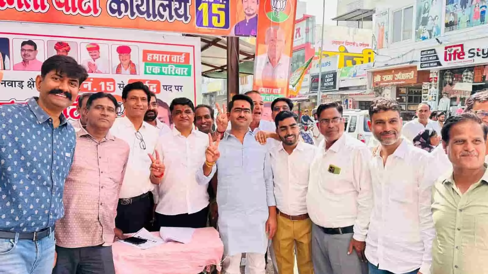 तस्वीर में एक चुनावी बैनर के सामने खड़े कई लोग विक्ट्री का साइन दिखाते हुए दिखाई दे रहे हैं। तस्वीर में एक चुनावी बैनर के सामने खड़े कई लोग विक्ट्री का साइन दिखाते हुए दिखाई दे रहे हैं।