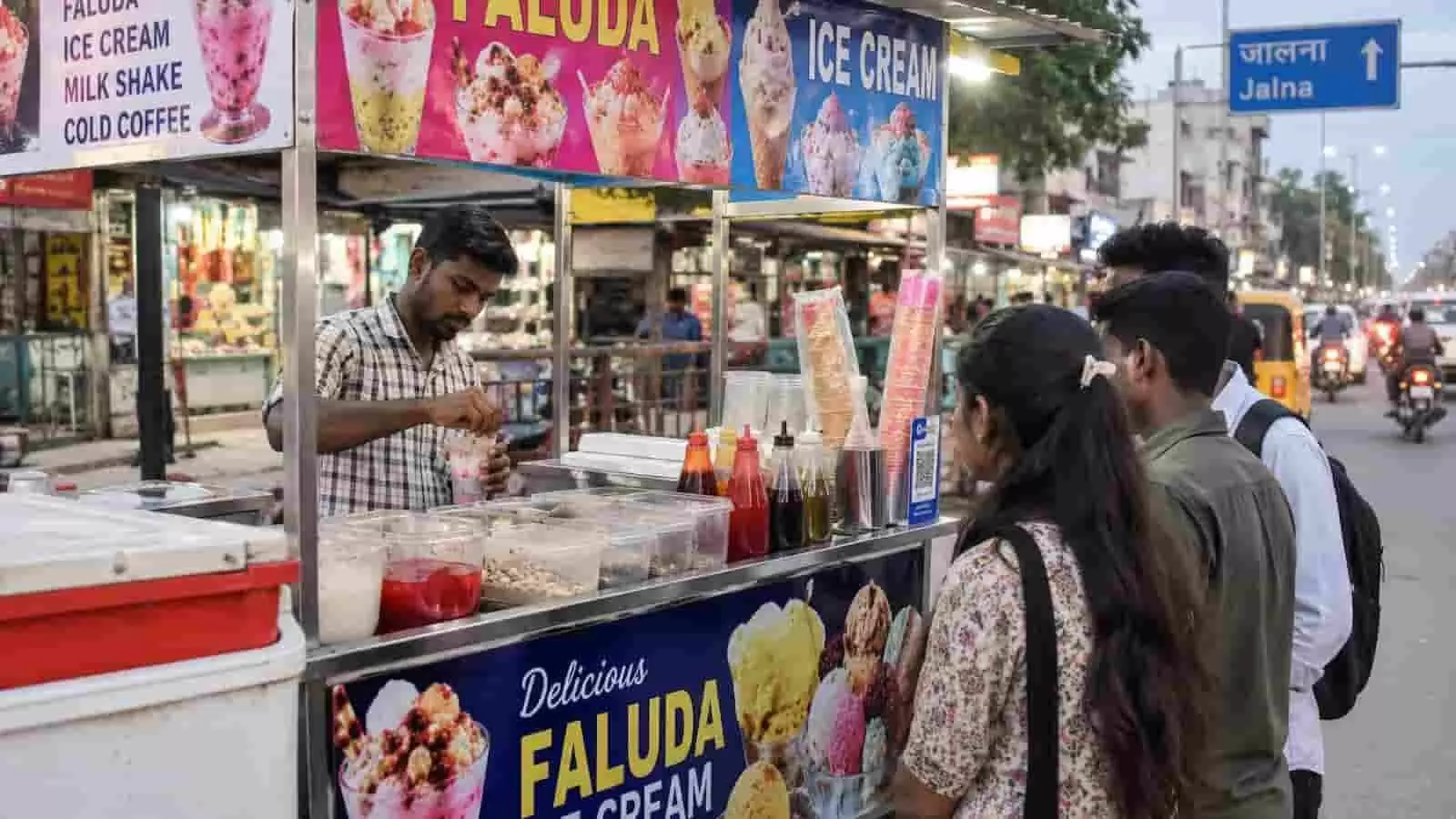 जालना में सड़क किनारे फालुदा और आइसक्रीम बेचता विक्रेता और खड़े ग्राहक। जालना में सड़क किनारे फालुदा और आइसक्रीम बेचता विक्रेता और खड़े ग्राहक।