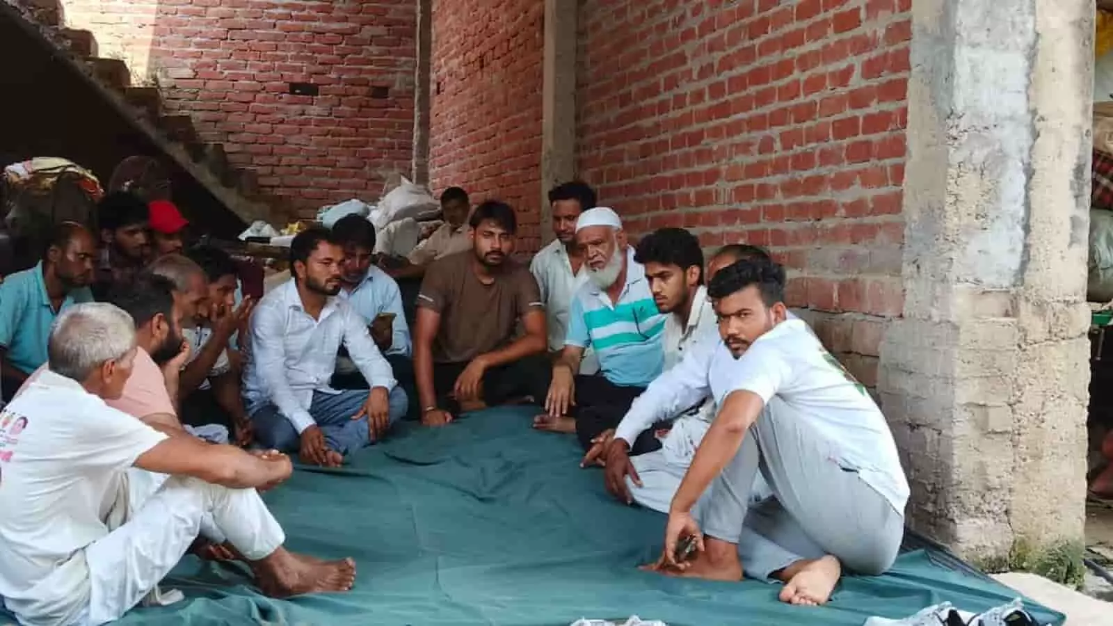 तस्वीर में एक घर के आंगन या बरामदे में फर्श पर कई लोग बैठे हुए हैं और आपस में चर्चा कर रहे हैं। तस्वीर में एक घर के आंगन या बरामदे में फर्श पर कई लोग बैठे हुए हैं और आपस में चर्चा कर रहे हैं।
