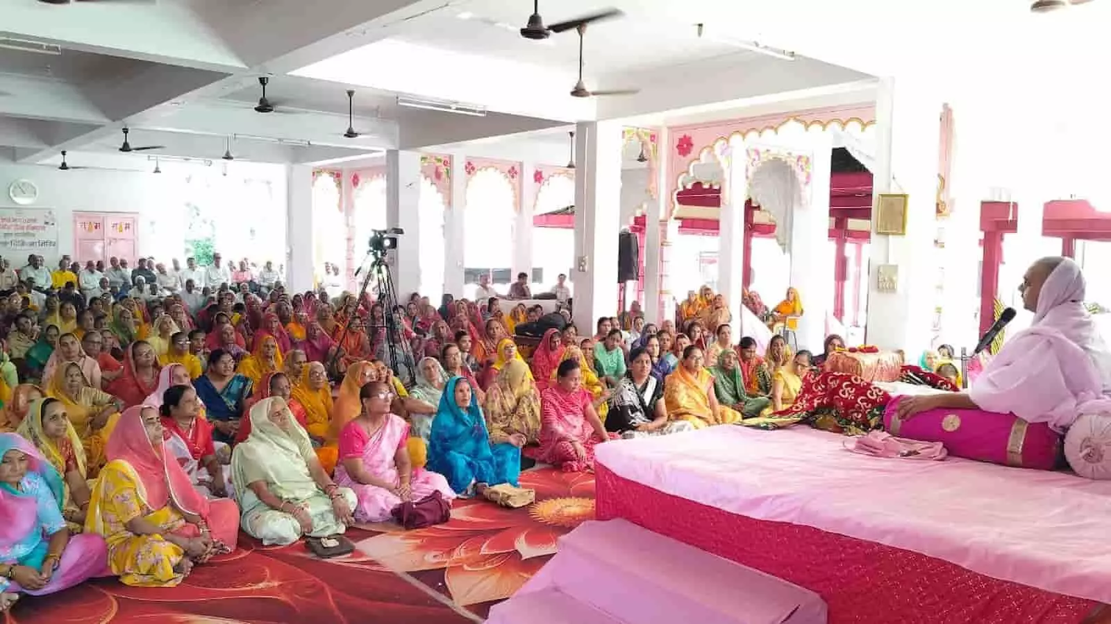तस्वीर में दाईं ओर मंच पर बैठे संत कथा वाचन कर रहे हैं और बाईं ओर बड़ी संख्या में महिलाएं जमीन पर बैठी कथा सुन रही हैं। तस्वीर में दाईं ओर मंच पर बैठे संत कथा वाचन कर रहे हैं और बाईं ओर बड़ी संख्या में महिलाएं जमीन पर बैठी कथा सुन रही हैं।