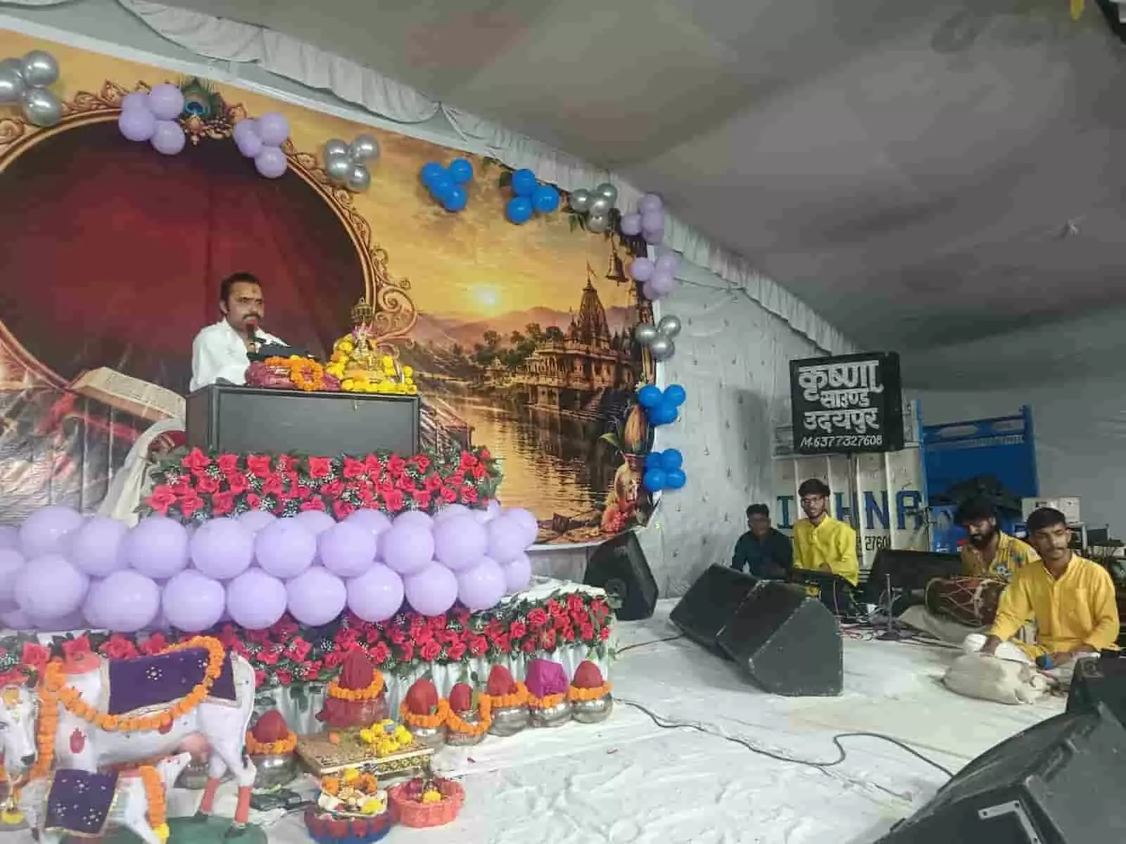 तस्वीर में सजाए गए मंच पर व्यासपीठ से कथावाचक और पास में वाद्ययंत्र बजाते कलाकार दिख रहे हैं। तस्वीर में सजाए गए मंच पर व्यासपीठ से कथावाचक और पास में वाद्ययंत्र बजाते कलाकार दिख रहे हैं।