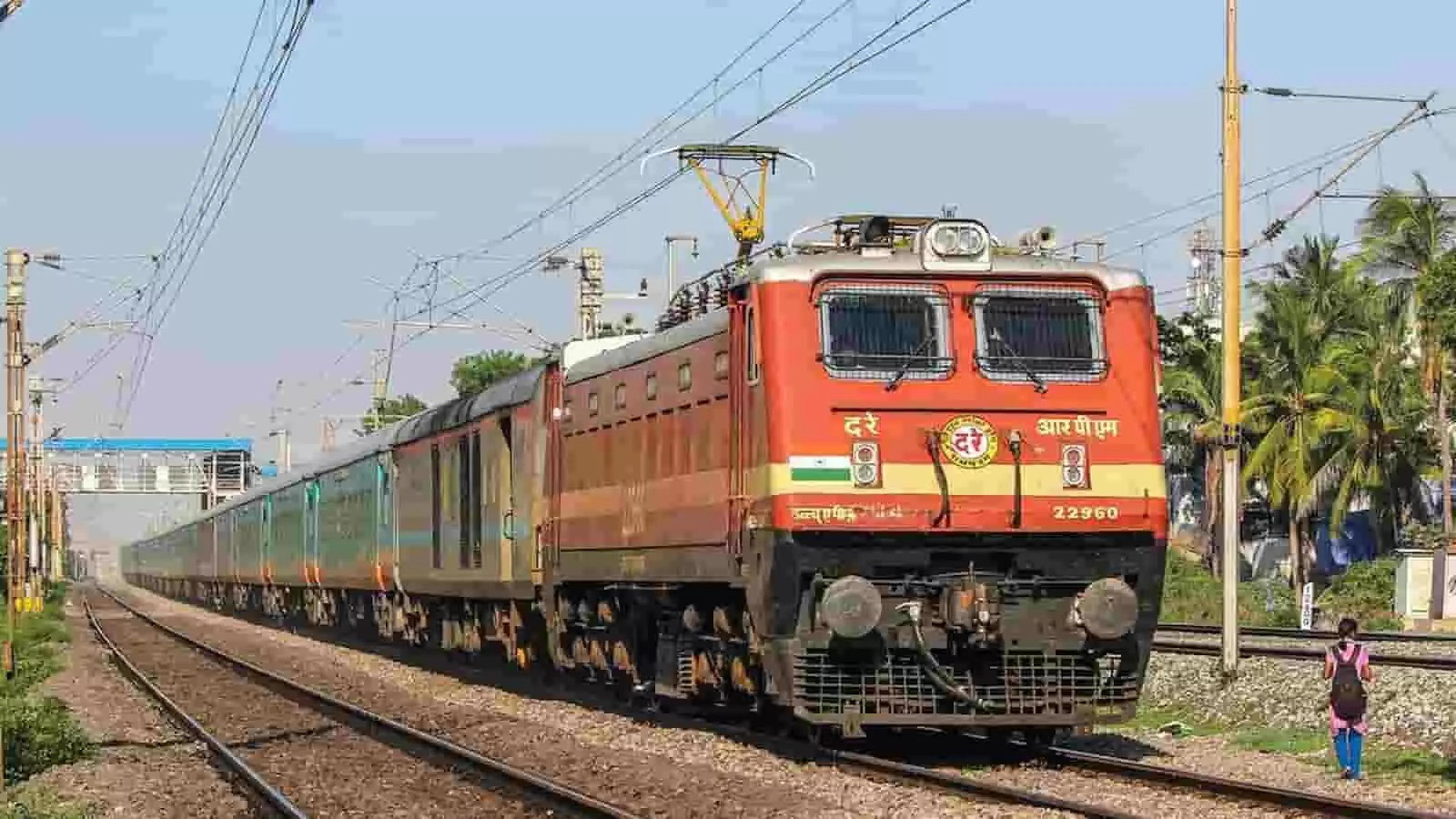 तस्वीर में रेलवे पटरी पर दौड़ती एक भारतीय पैसेंजर ट्रेन और पास में खड़ी लड़की दिख रही है। तस्वीर में रेलवे पटरी पर दौड़ती एक भारतीय पैसेंजर ट्रेन और पास में खड़ी लड़की दिख रही है।