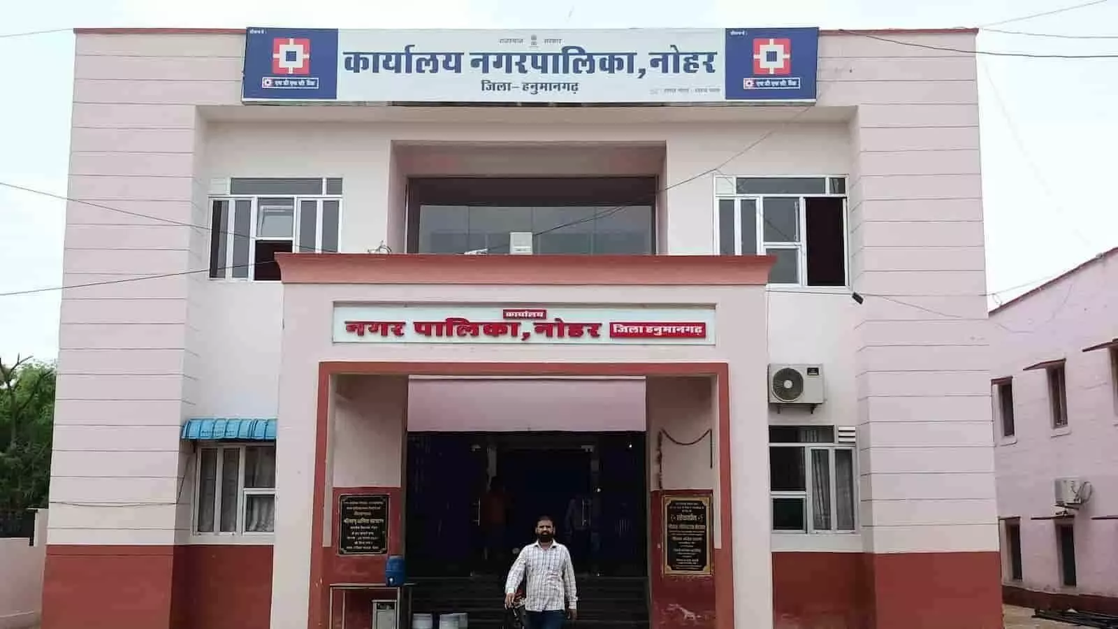 तस्वीर में हनुमानगढ़ स्थित नोहर नगरपालिका कार्यालय का मुख्य भवन और उसके सामने खड़ा व्यक्ति दिखाई दे रहा है। तस्वीर में हनुमानगढ़ स्थित नोहर नगरपालिका कार्यालय का मुख्य भवन और उसके सामने खड़ा व्यक्ति दिखाई दे रहा है।