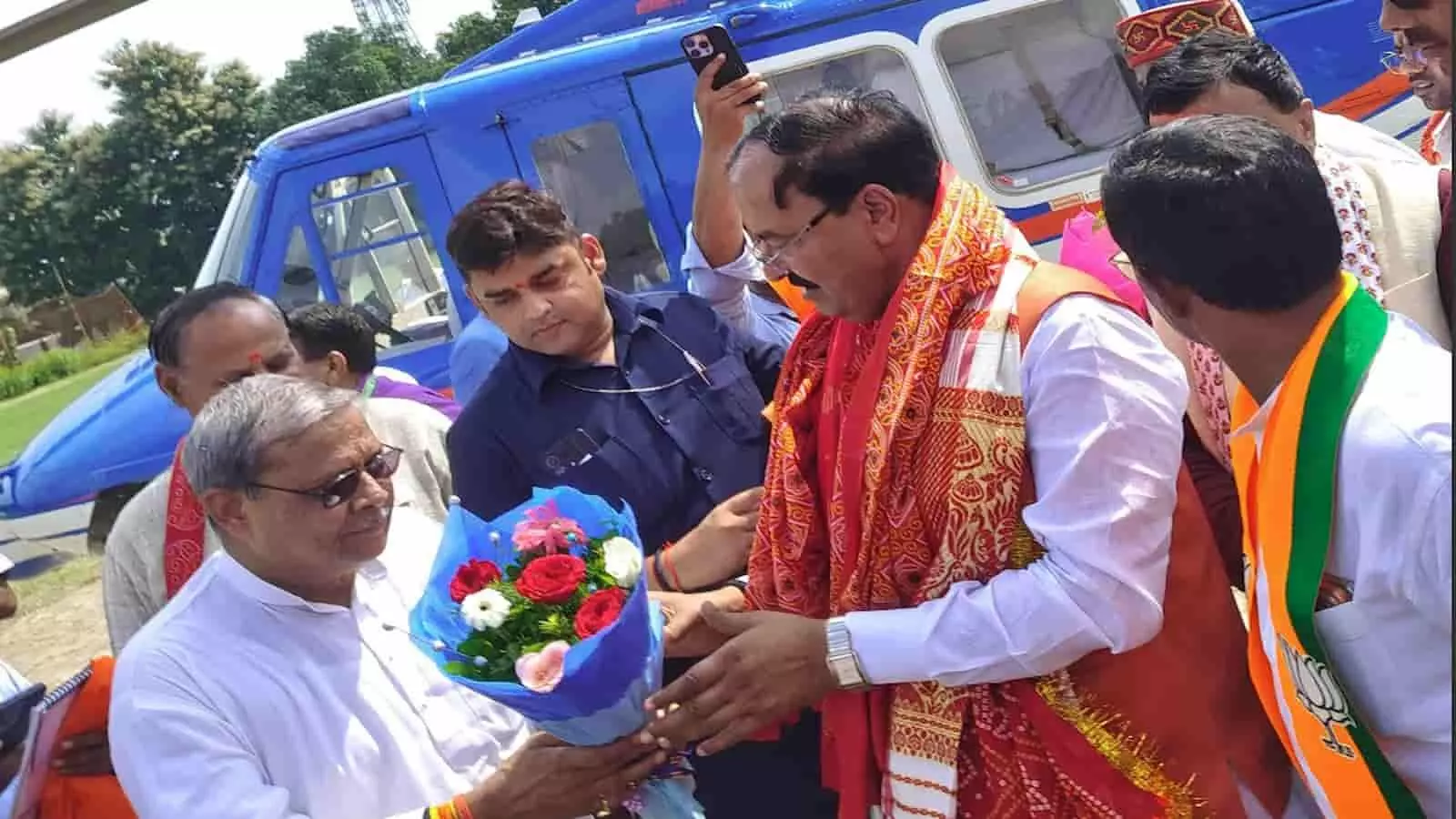 तस्वीर में नीले रंग के हेलिकॉप्टर के सामने खड़े उत्तर प्रदेश के डिप्टी सीएम केशव प्रसाद मौर्य को लोग गुलदस्ता भेंट कर रहे हैं। तस्वीर में नीले रंग के हेलिकॉप्टर के सामने खड़े उत्तर प्रदेश के डिप्टी सीएम केशव प्रसाद मौर्य को लोग गुलदस्ता भेंट कर रहे हैं।