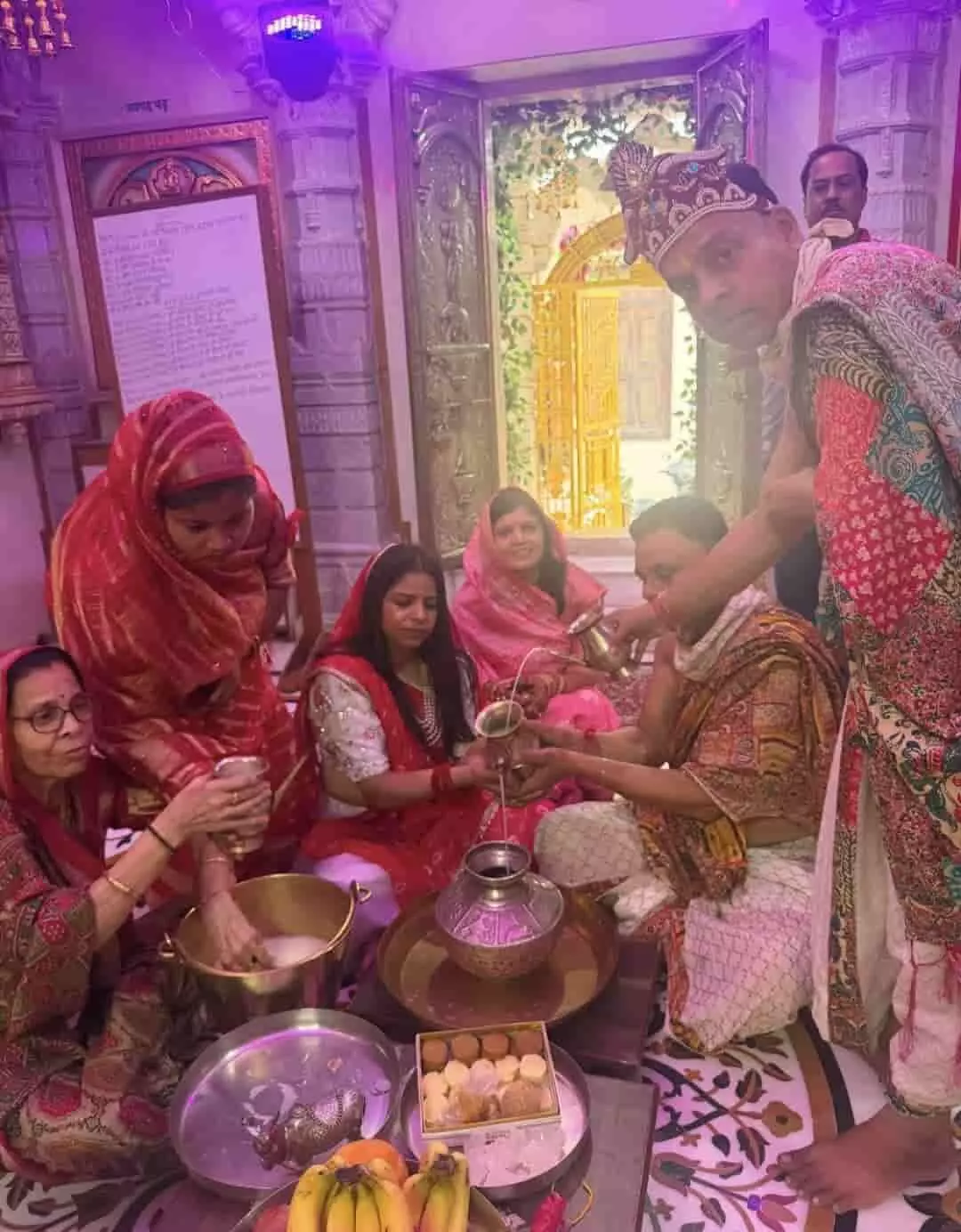 तस्वीर में महिलाएं और पुरुष पारंपरिक वेशभूषा में बैठकर कलश से जल अर्पित करते हुए धार्मिक अनुष्ठान संपन्न कर रहे हैं। तस्वीर में महिलाएं और पुरुष पारंपरिक वेशभूषा में बैठकर कलश से जल अर्पित करते हुए धार्मिक अनुष्ठान संपन्न कर रहे हैं।