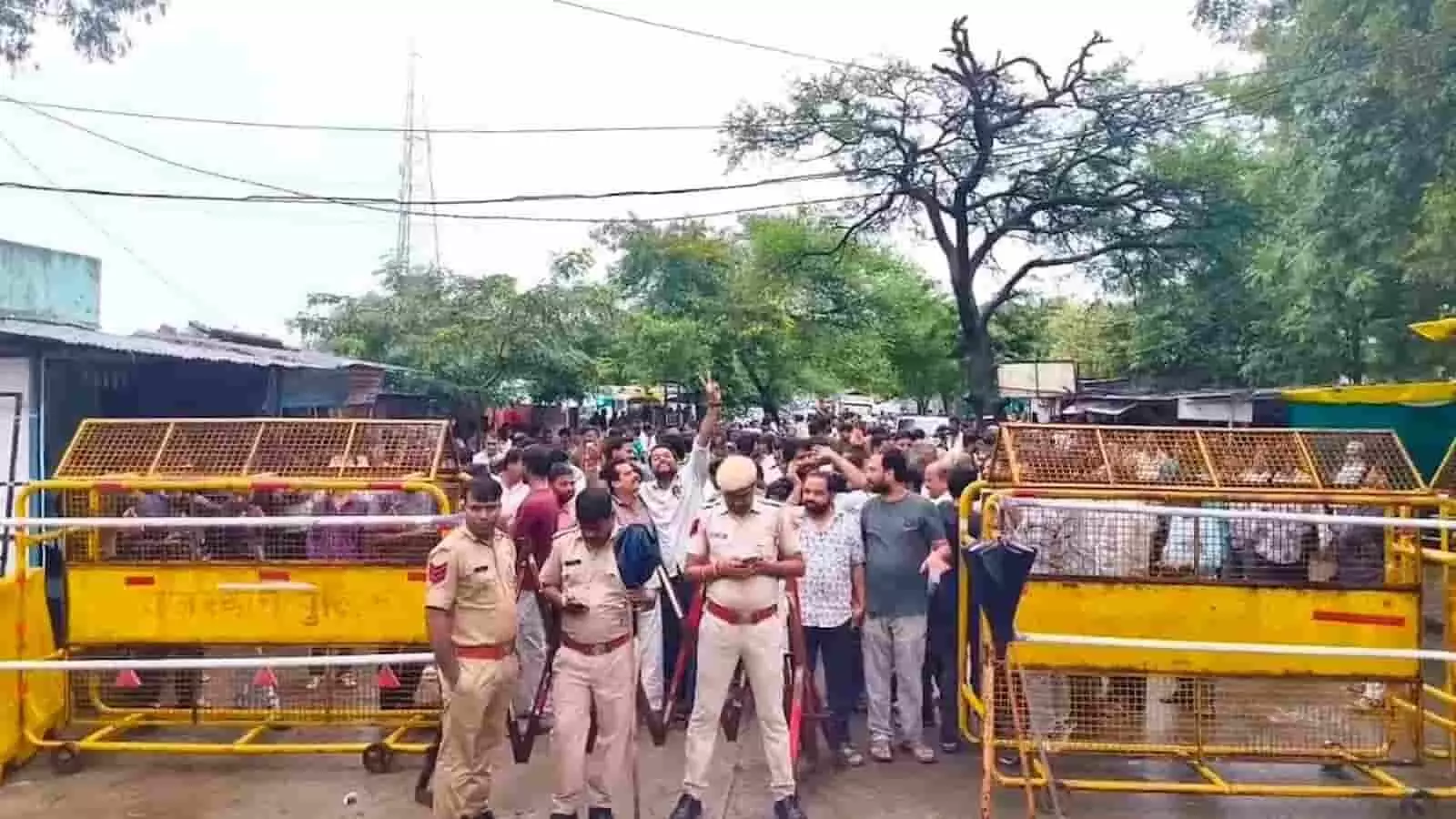 तस्वीर में मतगणना केंद्र के बाहर तैनात पुलिसकर्मी और बैरिकेड्स के पीछे खड़े लोग दिखाई दे रहे हैं। तस्वीर में मतगणना केंद्र के बाहर तैनात पुलिसकर्मी और बैरिकेड्स के पीछे खड़े लोग दिखाई दे रहे हैं।