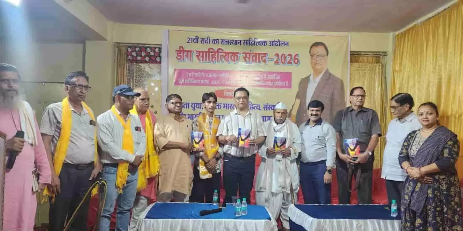 तस्वीर में डीग साहित्यिक संवाद के मंच पर खड़े अतिथि हाथ में किताबें लिए दिख रहे हैं। तस्वीर में डीग साहित्यिक संवाद के मंच पर खड़े अतिथि हाथ में किताबें लिए दिख रहे हैं।