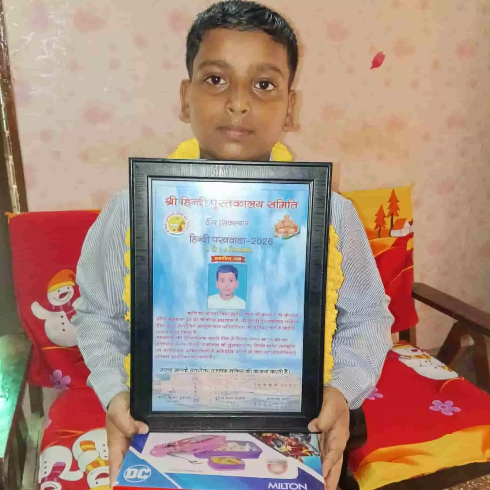 तस्वीर में दिख रहा छात्र हाथ में पुरस्कार पत्र और उपहार लेकर सामने देख रहा है। तस्वीर में दिख रहा छात्र हाथ में पुरस्कार पत्र और उपहार लेकर सामने देख रहा है।
