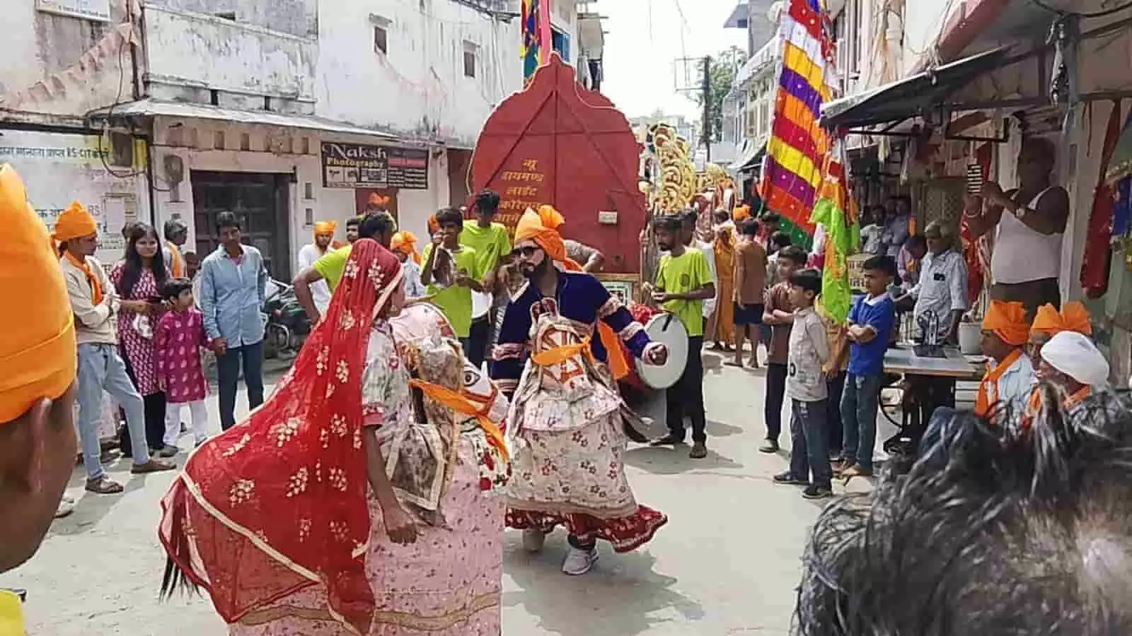 तस्वीर में घोड़ी जैसे पारंपरिक रूप धारण किए हुए लोग और भीड़भाड़ वाली सड़क पर जुलूस में शामिल श्रद्धालु दिखाई दे रहे हैं। तस्वीर में घोड़ी जैसे पारंपरिक रूप धारण किए हुए लोग और भीड़भाड़ वाली सड़क पर जुलूस में शामिल श्रद्धालु दिखाई दे रहे हैं।
