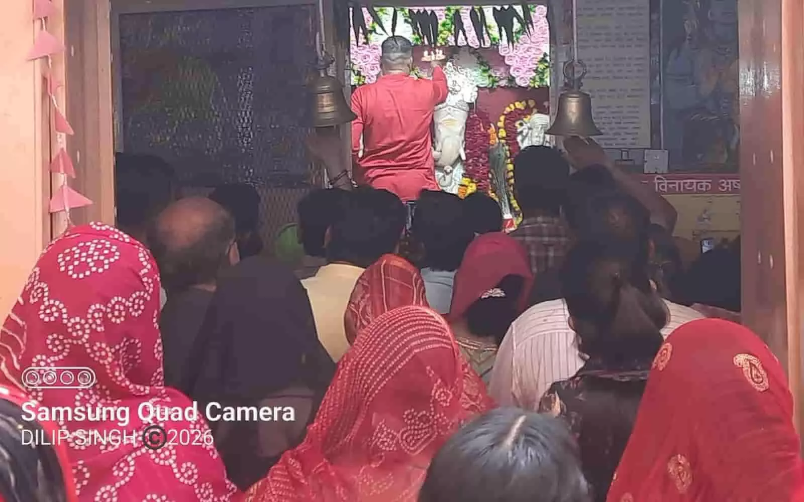 तस्वीर में मंदिर के गर्भगृह में पुजारी मूर्ति का श्रृंगार कर रहे हैं और सामने श्रद्धालु दर्शन कर रहे हैं। तस्वीर में मंदिर के गर्भगृह में पुजारी मूर्ति का श्रृंगार कर रहे हैं और सामने श्रद्धालु दर्शन कर रहे हैं।