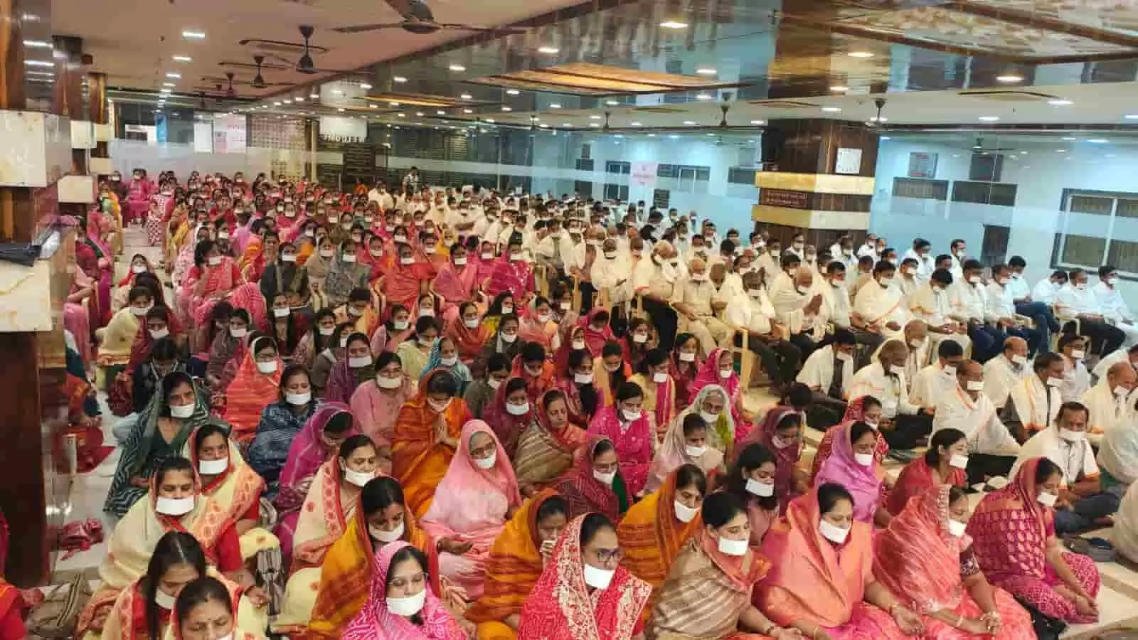 तस्वीर में एक बड़े हॉल में फर्श और कुर्सियों पर बैठकर साधना और मंत्रानुष्ठान में भाग लेते हुए श्रद्धालु दिखाई दे रहे हैं। तस्वीर में एक बड़े हॉल में फर्श और कुर्सियों पर बैठकर साधना और मंत्रानुष्ठान में भाग लेते हुए श्रद्धालु दिखाई दे रहे हैं।