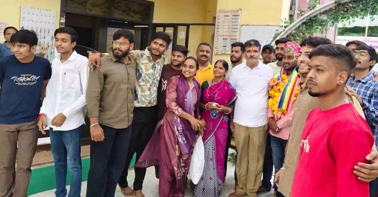 तस्वीर में माला पहने अर्पित जैन और उनके साथी एक परिसर के बाहर समूह में खड़े हैं। तस्वीर में माला पहने अर्पित जैन और उनके साथी एक परिसर के बाहर समूह में खड़े हैं।