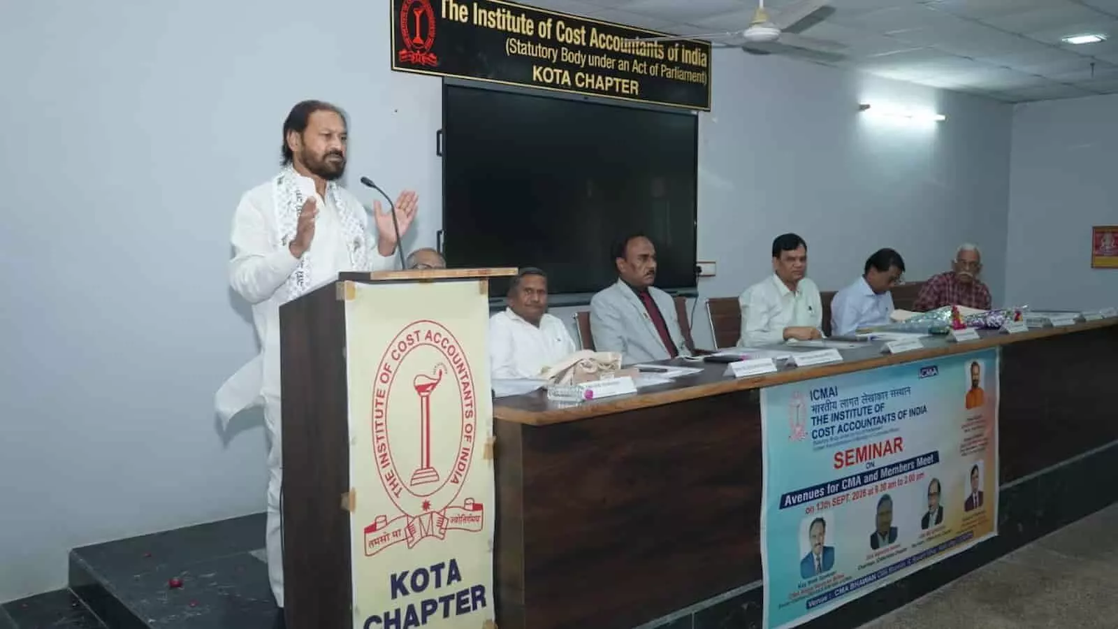 तस्वीर में पोडियम पर खड़े होकर भाषण देते मुख्य अतिथि और मंच पर बैठे अन्य लोग दिख रहे हैं। तस्वीर में पोडियम पर खड़े होकर भाषण देते मुख्य अतिथि और मंच पर बैठे अन्य लोग दिख रहे हैं।