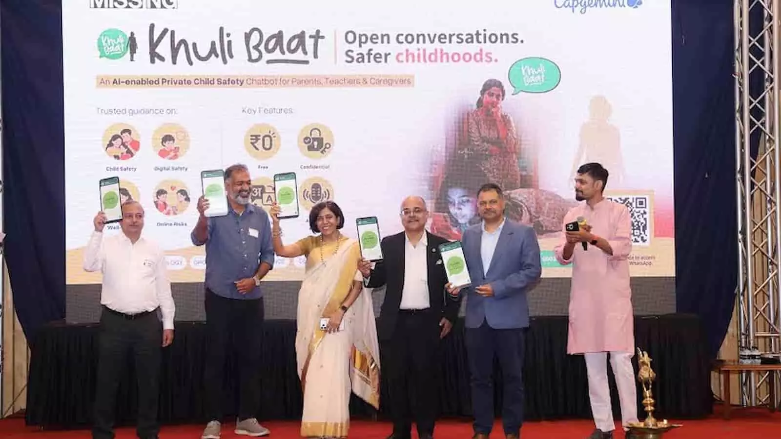 तस्वीर में मंच पर बाईं से दाईं ओर पांच लोग खड़े हैं और अपने हाथ में फोन पकड़े हुए हैं। तस्वीर में मंच पर बाईं से दाईं ओर पांच लोग खड़े हैं और अपने हाथ में फोन पकड़े हुए हैं।