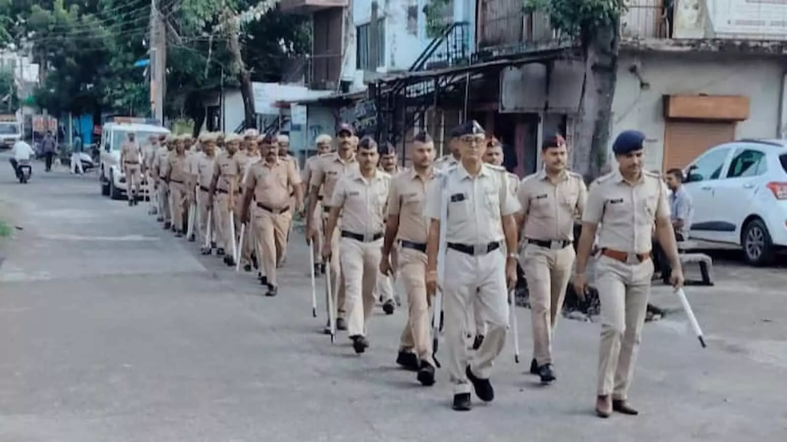 तस्वीर में खाकी वर्दी पहने पुलिसकर्मी सड़क पर कतारबद्ध होकर रूटमार्च करते हुए आगे बढ़ रहे हैं। तस्वीर में खाकी वर्दी पहने पुलिसकर्मी सड़क पर कतारबद्ध होकर रूटमार्च करते हुए आगे बढ़ रहे हैं।