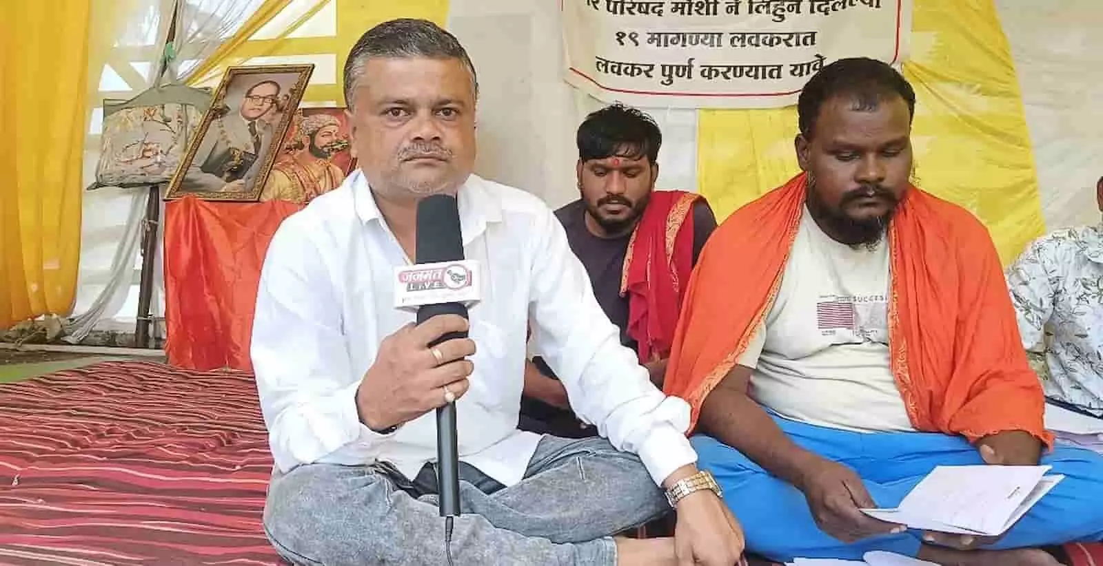 तस्वीर में बाएं सफेद शर्ट पहने व्यक्ति माइक पर बोलते हुए और दाएं व्यक्ति अनशन पर बैठा दिख रहा है। तस्वीर में बाएं सफेद शर्ट पहने व्यक्ति माइक पर बोलते हुए और दाएं व्यक्ति अनशन पर बैठा दिख रहा है।