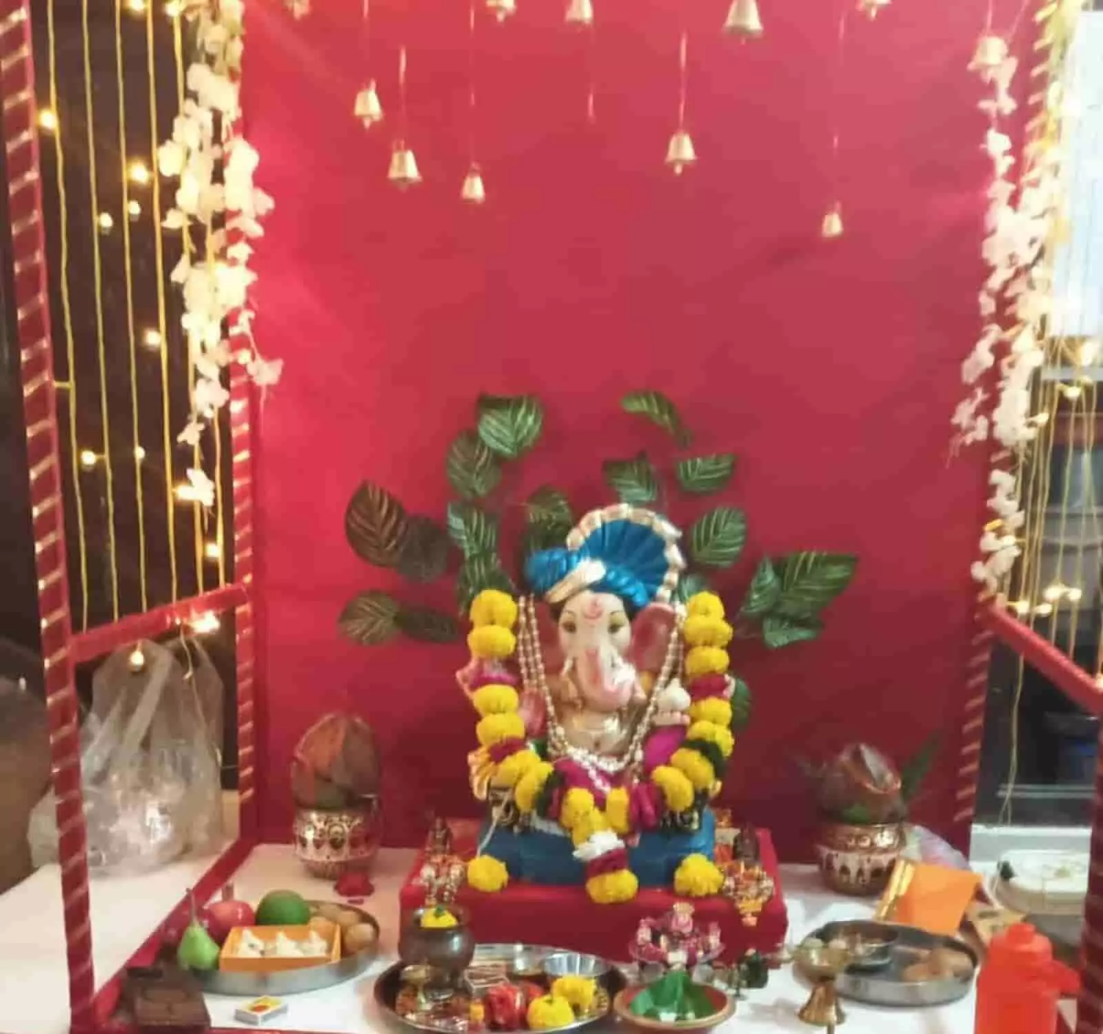 तस्वीर में दिख रही फूलों की माला से सजी भगवान गणेश की प्रतिमा और पूजा सामग्री रखी है। तस्वीर में दिख रही फूलों की माला से सजी भगवान गणेश की प्रतिमा और पूजा सामग्री रखी है।