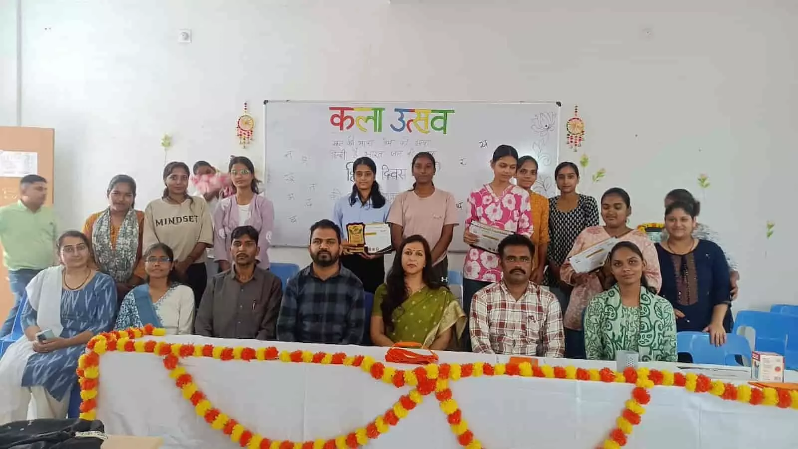तस्वीर में दिख रही जगह पर शिक्षक आगे बैठे हैं और पीछे छात्राएं ट्रॉफी और प्रमाण पत्र लिए खड़ी हैं। तस्वीर में दिख रही जगह पर शिक्षक आगे बैठे हैं और पीछे छात्राएं ट्रॉफी और प्रमाण पत्र लिए खड़ी हैं।