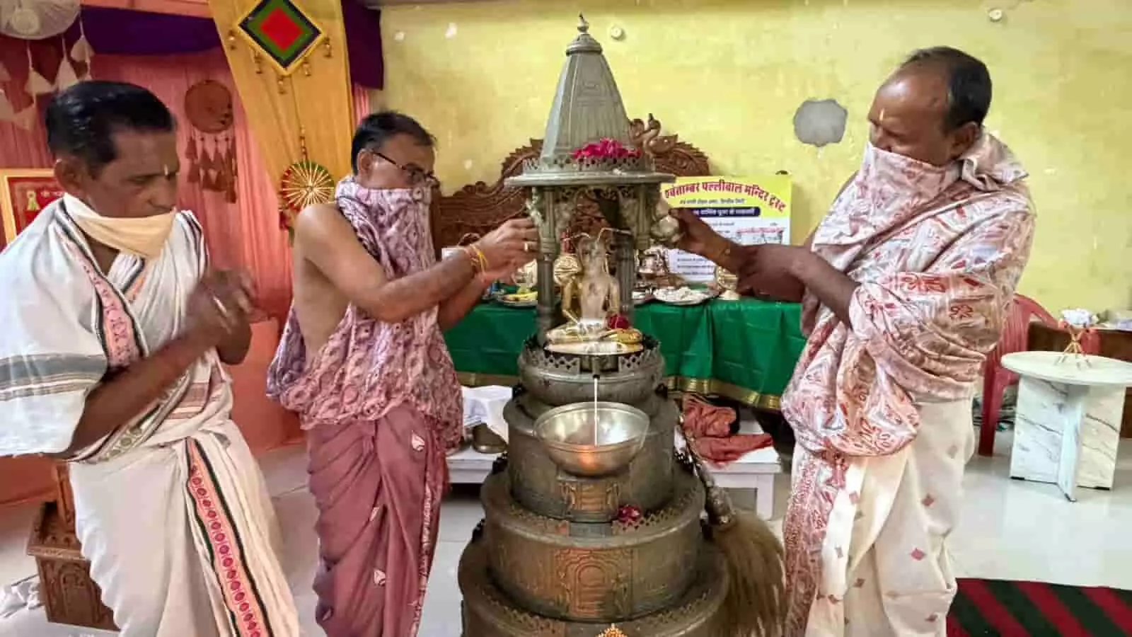 तस्वीर में एक मंदिर के अंदर भगवान की मूर्ति का अभिषेक करते हुए और खड़े हुए कई श्रद्धालु नजर आ रहे हैं. तस्वीर में एक मंदिर के अंदर भगवान की मूर्ति का अभिषेक करते हुए और खड़े हुए कई श्रद्धालु नजर आ रहे हैं.