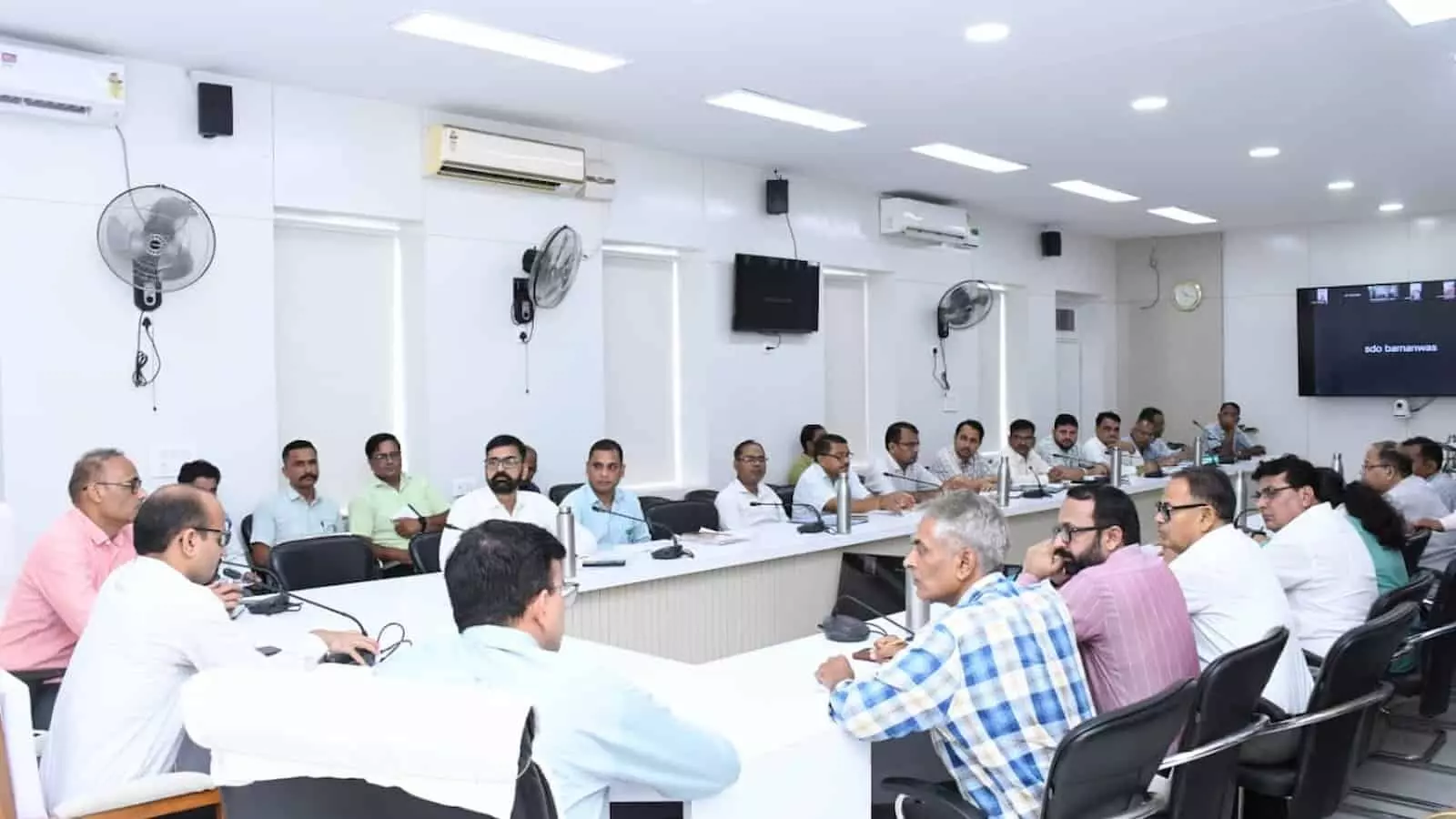 तस्वीर में एक कॉन्फ्रेंस हॉल में बड़ी मेज के चारों ओर कुर्सियों पर बैठे हुए कई अधिकारी नजर आ रहे हैं। तस्वीर में एक कॉन्फ्रेंस हॉल में बड़ी मेज के चारों ओर कुर्सियों पर बैठे हुए कई अधिकारी नजर आ रहे हैं।