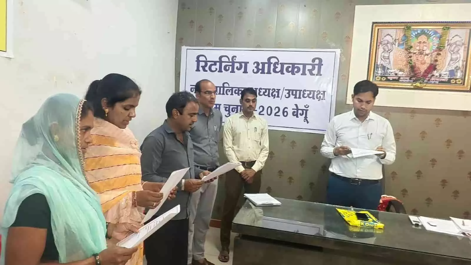 तस्वीर में बाएं खड़े पार्षद कागज पढ़कर शपथ ले रहे हैं और दाईं तरफ अधिकारी खड़े हैं। तस्वीर में बाएं खड़े पार्षद कागज पढ़कर शपथ ले रहे हैं और दाईं तरफ अधिकारी खड़े हैं।