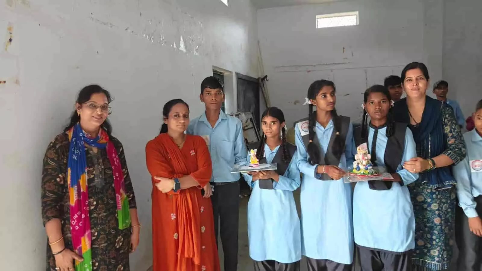 तस्वीर में बाएं से दाएं शिक्षिका, महिला शिक्षिका, एक छात्र और तीन छात्राएं हाथ में गणेश प्रतिमा थामे खड़े हैं। तस्वीर में बाएं से दाएं शिक्षिका, महिला शिक्षिका, एक छात्र और तीन छात्राएं हाथ में गणेश प्रतिमा थामे खड़े हैं।