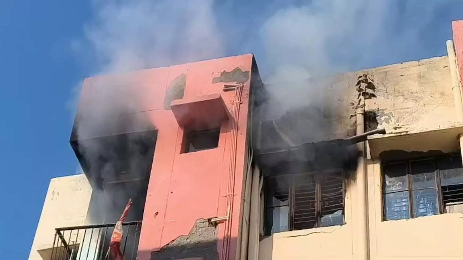तस्वीर में एक बहुमंजिला आवासीय इमारत की बालकनी और खिड़कियों से घुप काला धुआं उठ रहा है. तस्वीर में एक बहुमंजिला आवासीय इमारत की बालकनी और खिड़कियों से घुप काला धुआं उठ रहा है.
