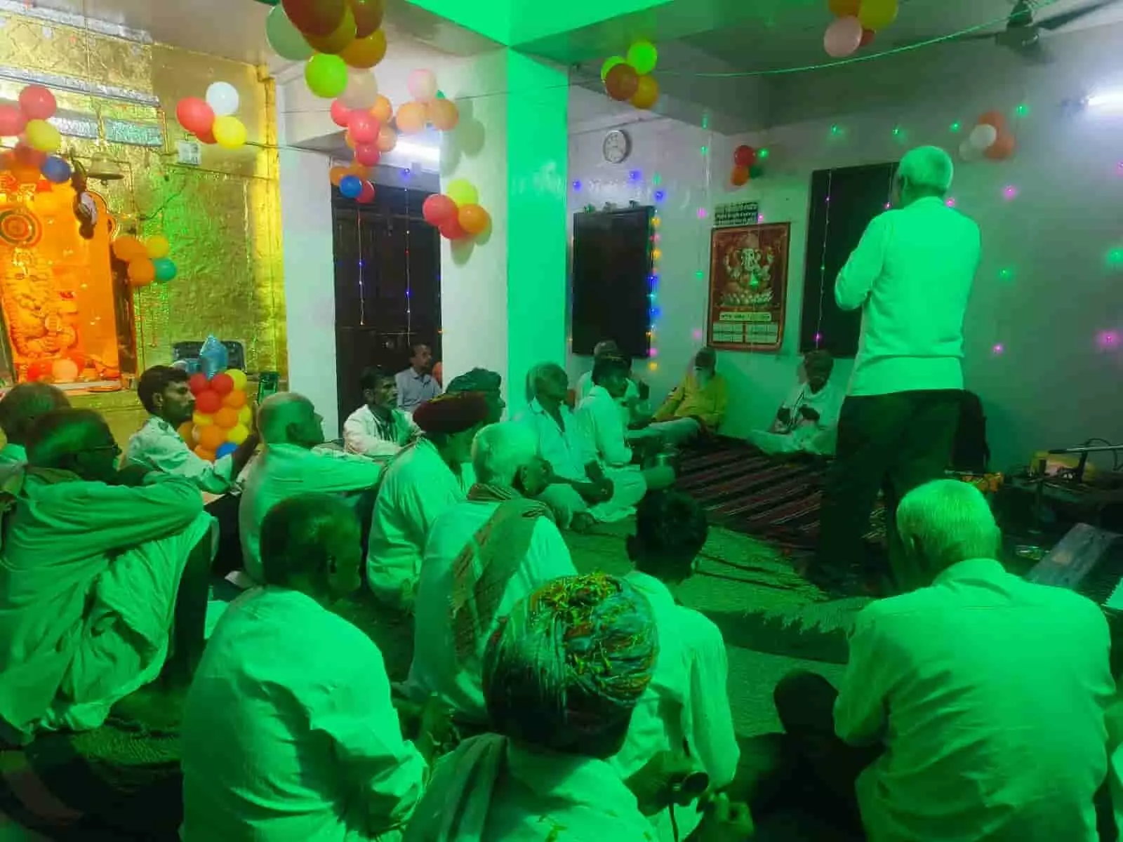 सजावट वाले हॉल में जमीन पर बैठे श्रद्धालु भजन संध्या कार्यक्रम में एक व्यक्ति की प्रस्तुति सुन रहे हैं। सजावट वाले हॉल में जमीन पर बैठे श्रद्धालु भजन संध्या कार्यक्रम में एक व्यक्ति की प्रस्तुति सुन रहे हैं।