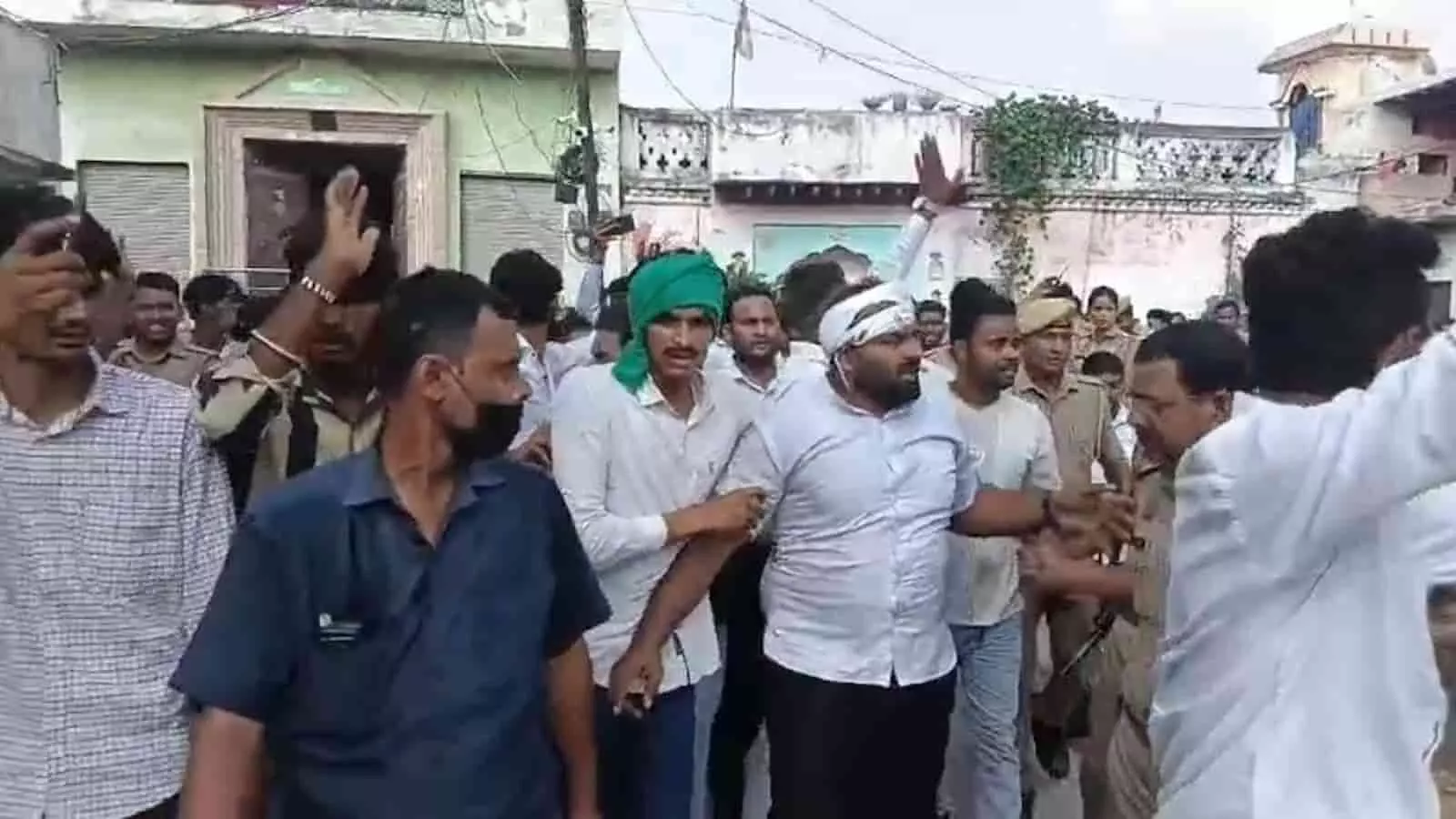 तस्वीर में बाएं से दाएं कई समर्थक और पुलिसकर्मियों के बीच रवि गौतम हाथ उठाकर विरोध जताते दिख रहे हैं। तस्वीर में बाएं से दाएं कई समर्थक और पुलिसकर्मियों के बीच रवि गौतम हाथ उठाकर विरोध जताते दिख रहे हैं।