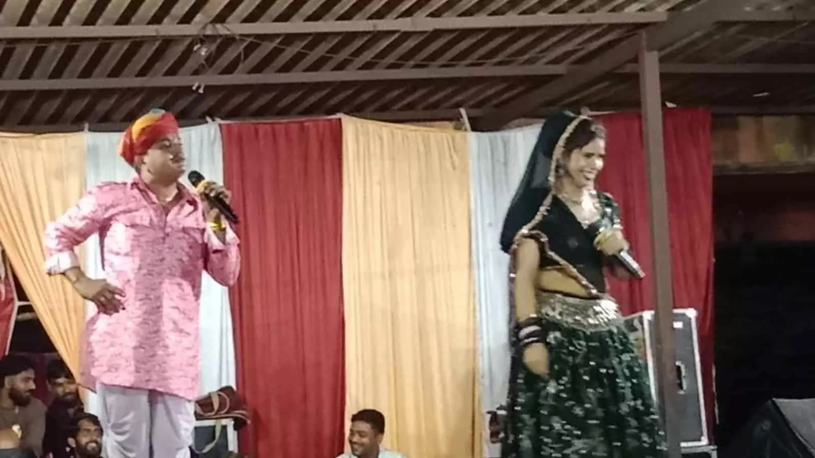 तस्वीर में बाईं ओर राजस्थानी साफा पहने पुरुष और दाईं ओर पारंपरिक पोशाक में महिला मंच पर प्रस्तुति दे रही हैं। तस्वीर में बाईं ओर राजस्थानी साफा पहने पुरुष और दाईं ओर पारंपरिक पोशाक में महिला मंच पर प्रस्तुति दे रही हैं।