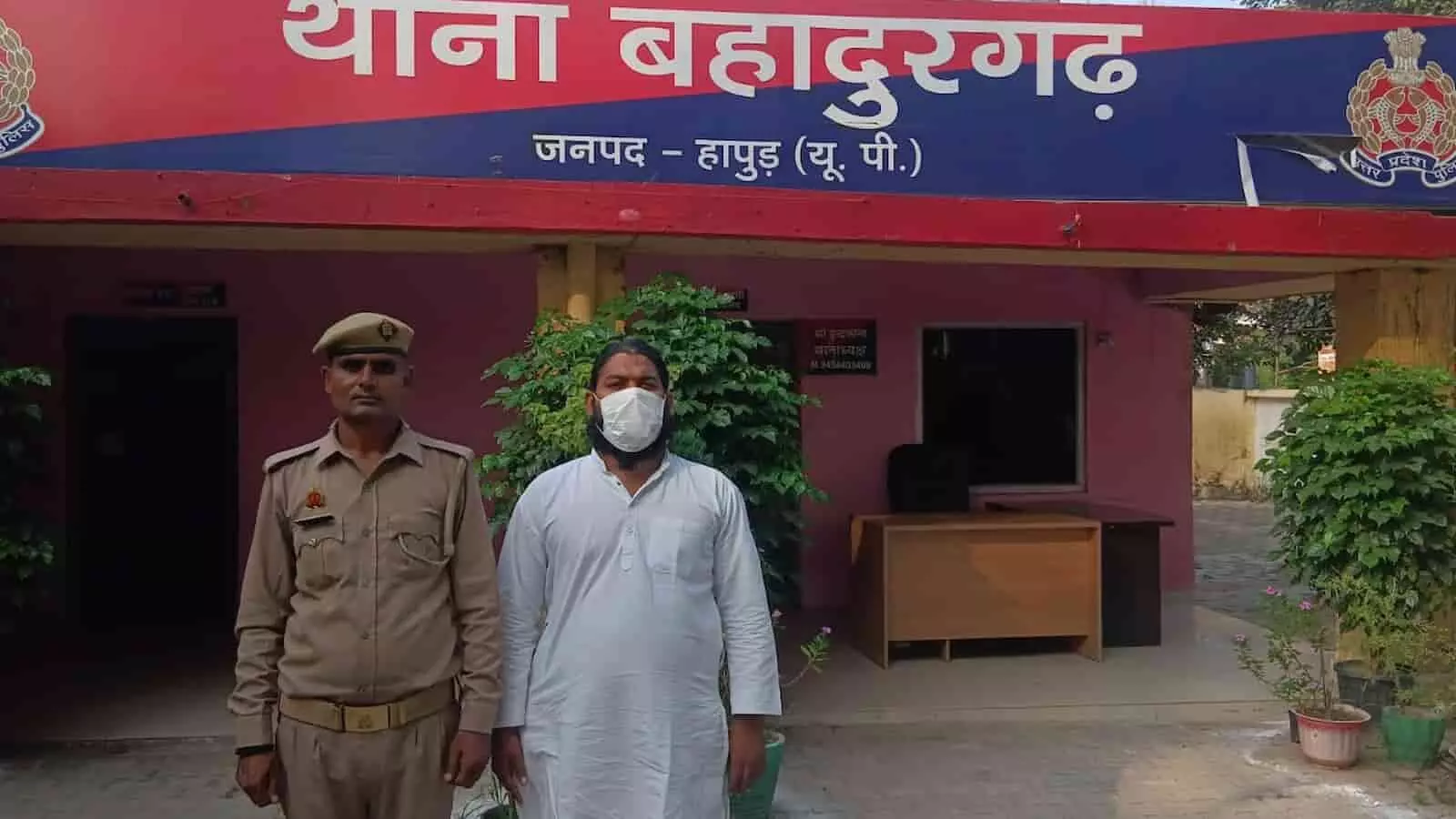 तस्वीर में एक पुलिसकर्मी और सफेद कुर्ता पहने आरोपी थाने के बाहर खड़े हैं, जिसके पीछे थाना बहादुरगढ़ का बोर्ड लगा हुआ है। तस्वीर में एक पुलिसकर्मी और सफेद कुर्ता पहने आरोपी थाने के बाहर खड़े हैं, जिसके पीछे थाना बहादुरगढ़ का बोर्ड लगा हुआ है।