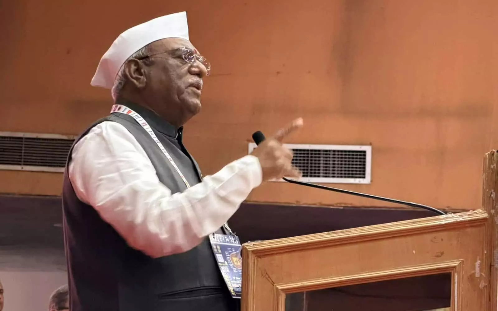 तस्वीर में सफेद टोपी पहने राज्यपाल हरिभाऊ बागडे पोडियम पर माइक के सामने बोल रहे हैं। तस्वीर में सफेद टोपी पहने राज्यपाल हरिभाऊ बागडे पोडियम पर माइक के सामने बोल रहे हैं।