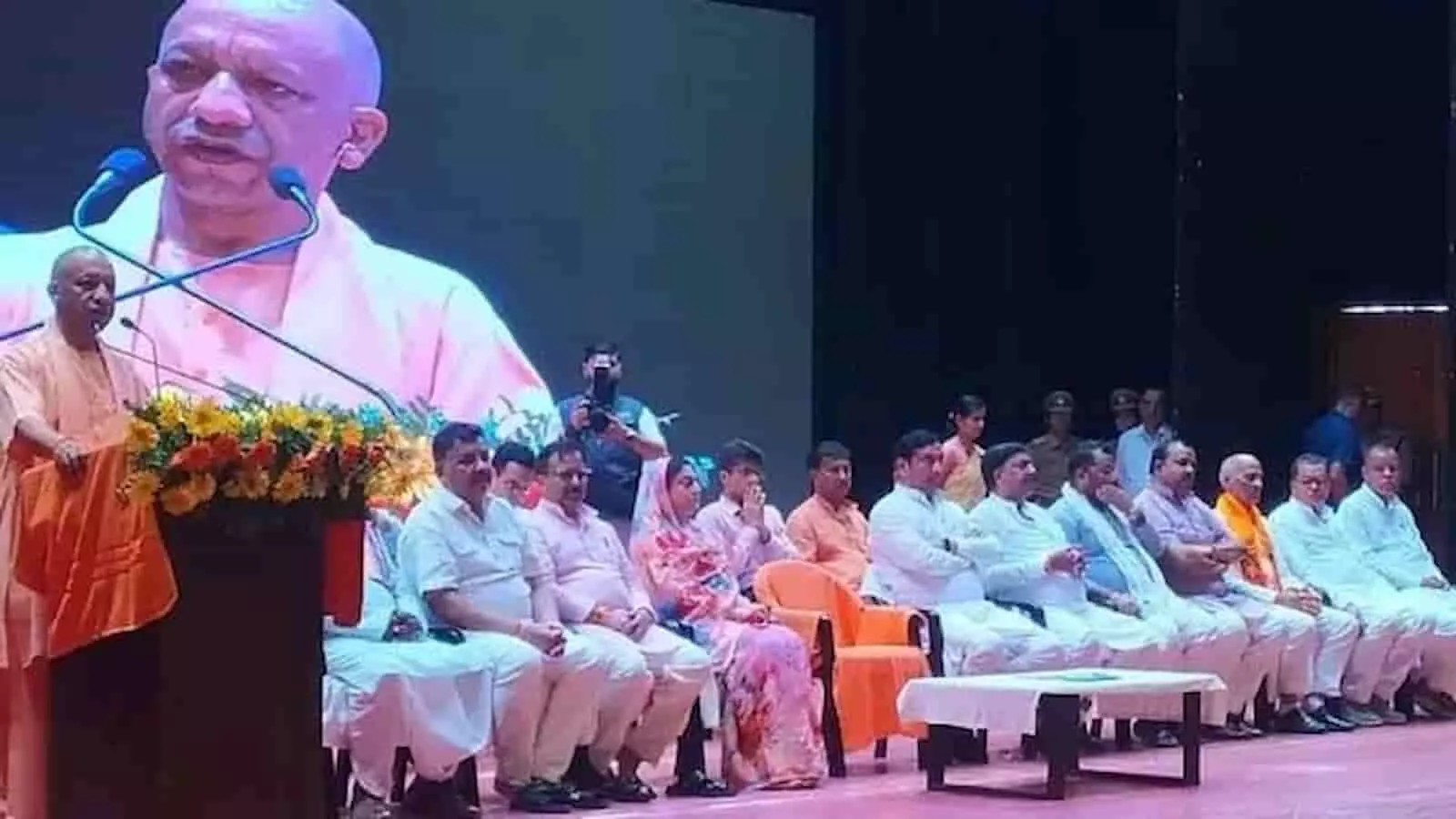 तस्वीर में मुख्यमंत्री योगी आदित्यनाथ मंच पर भाषण दे रहे हैं और श्रोतागण नीचे बैठे हैं। तस्वीर में मुख्यमंत्री योगी आदित्यनाथ मंच पर भाषण दे रहे हैं और श्रोतागण नीचे बैठे हैं।