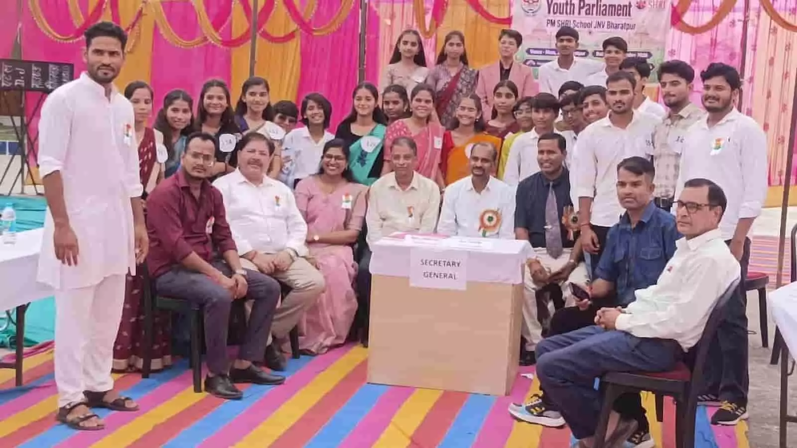 तस्वीर में दिख रही यूथ पार्लियामेंट में मंच पर अतिथि कुर्सियों पर बैठे हैं और विद्यार्थी पीछे खड़े हैं। तस्वीर में दिख रही यूथ पार्लियामेंट में मंच पर अतिथि कुर्सियों पर बैठे हैं और विद्यार्थी पीछे खड़े हैं।