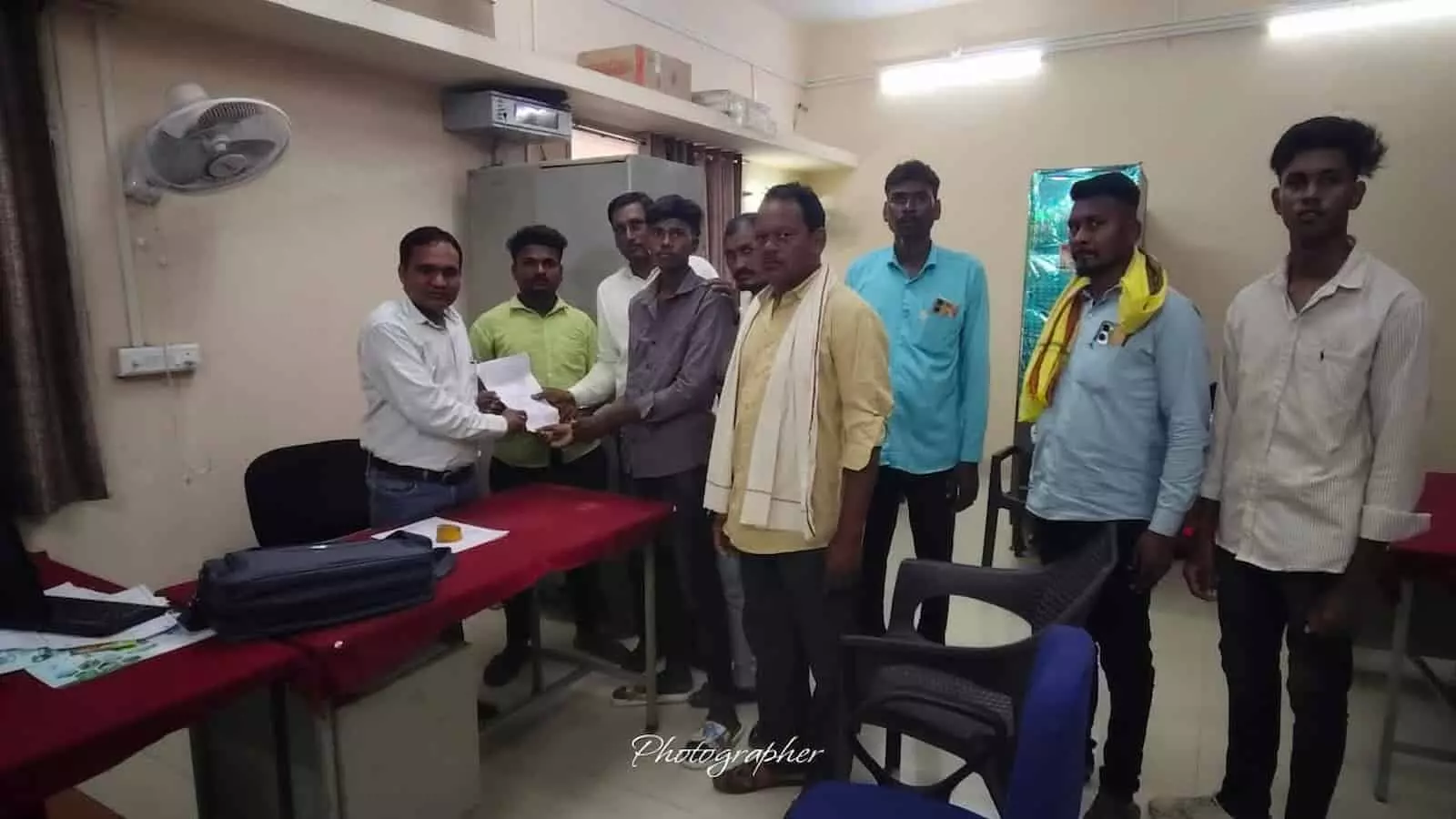 तस्वीर में बाएं से दाएं खड़े ग्रामीण दफ्तर में टेबल के पास मौजूद अधिकारी को पत्र दे रहे हैं। तस्वीर में बाएं से दाएं खड़े ग्रामीण दफ्तर में टेबल के पास मौजूद अधिकारी को पत्र दे रहे हैं।