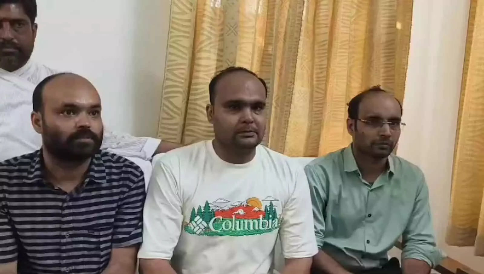 तस्वीर में बाएं से दाएं बैठे तीन व्यक्ति कमरे के अंदर शांत मुद्रा में नजर आ रहे हैं। तस्वीर में बाएं से दाएं बैठे तीन व्यक्ति कमरे के अंदर शांत मुद्रा में नजर आ रहे हैं।