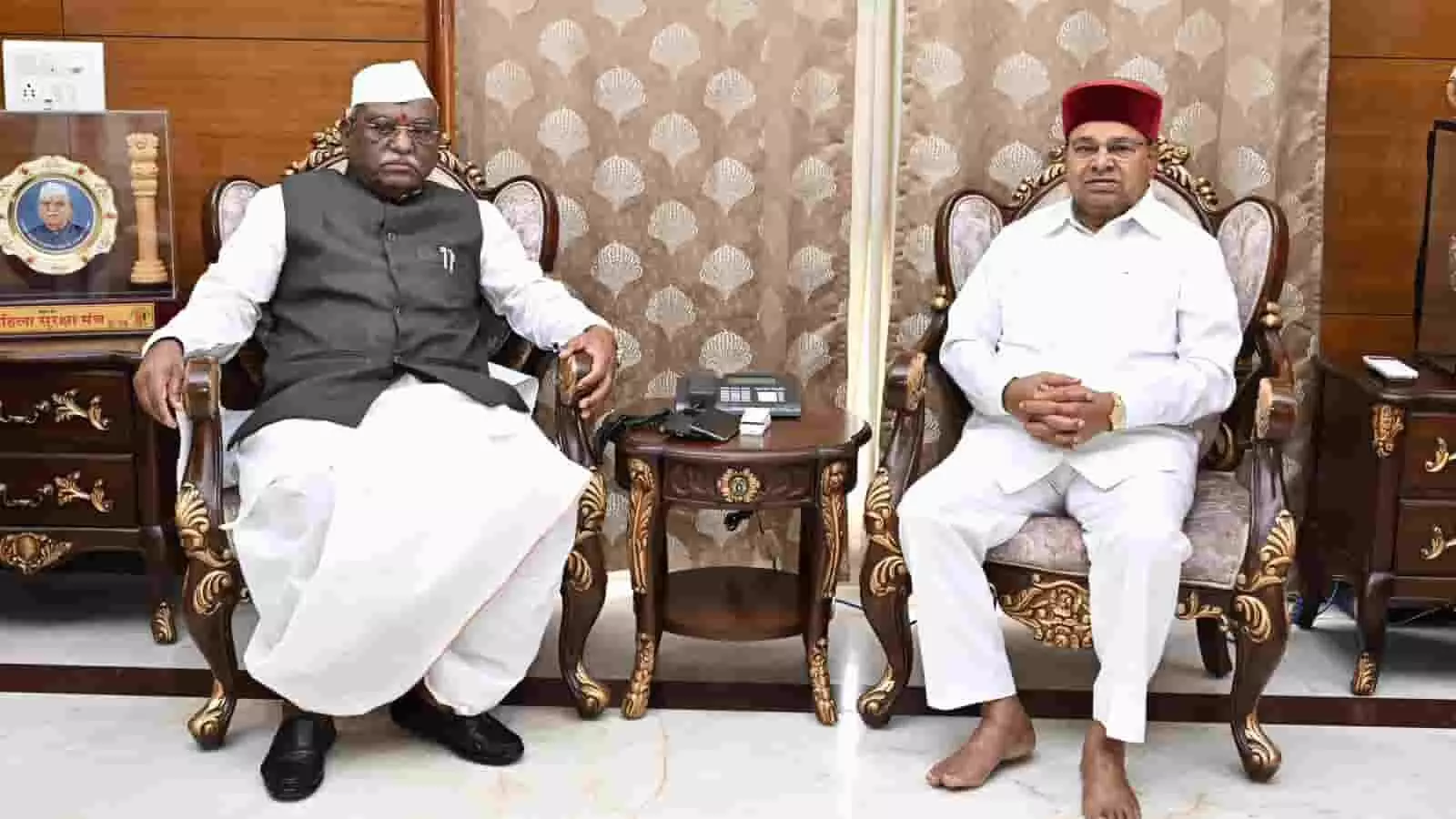 तस्वीर में दो व्यक्ति एक कार्यालय या कमरे में सोफे पर बैठे दिखाई दे रहे हैं। तस्वीर में दो व्यक्ति एक कार्यालय या कमरे में सोफे पर बैठे दिखाई दे रहे हैं।